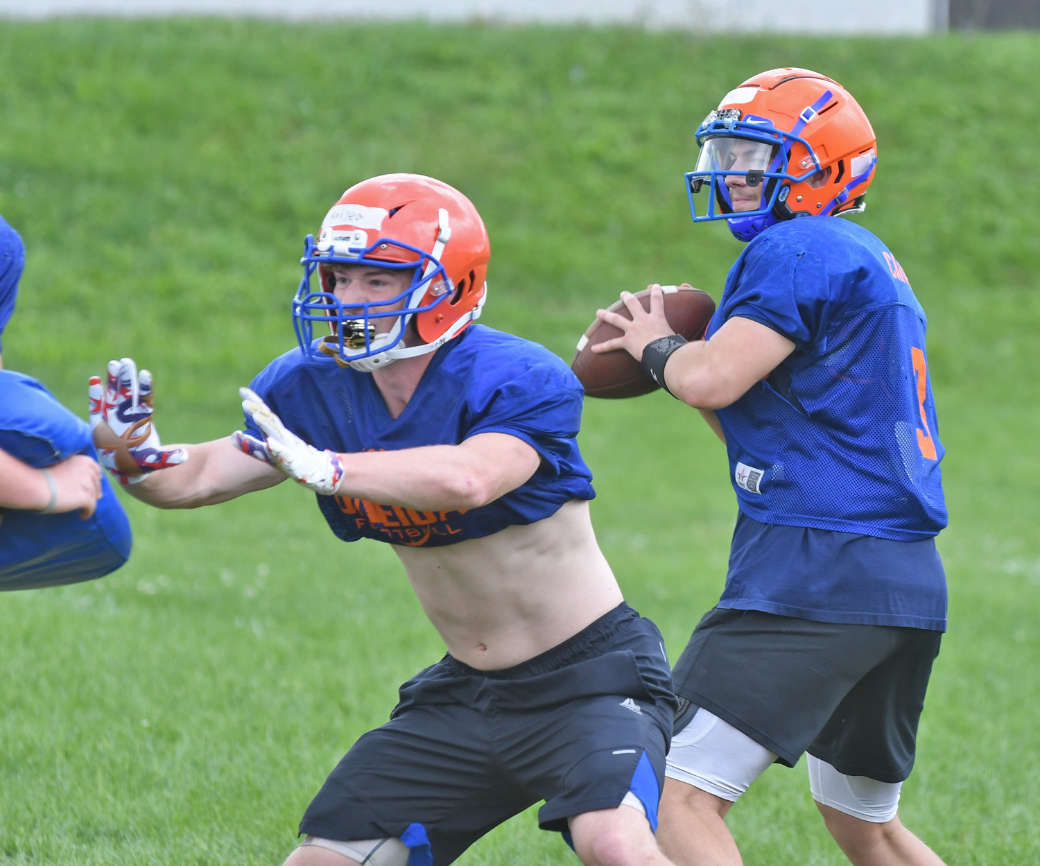 Oneida junior quarterback Bryson Carinci looks downfield to throw as junior running back Pierce Relyea blocks for him during a practice.