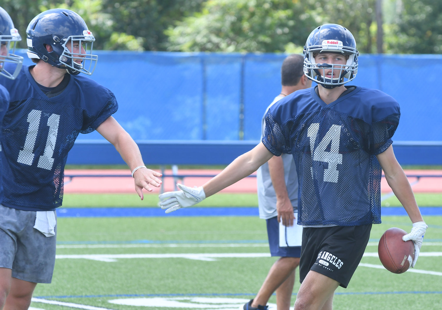 Whitesboro quarterback Kyle Meier, left, and receiver Gavin Foley share a low five during practice at Edwin Wadas Athletic Complex.