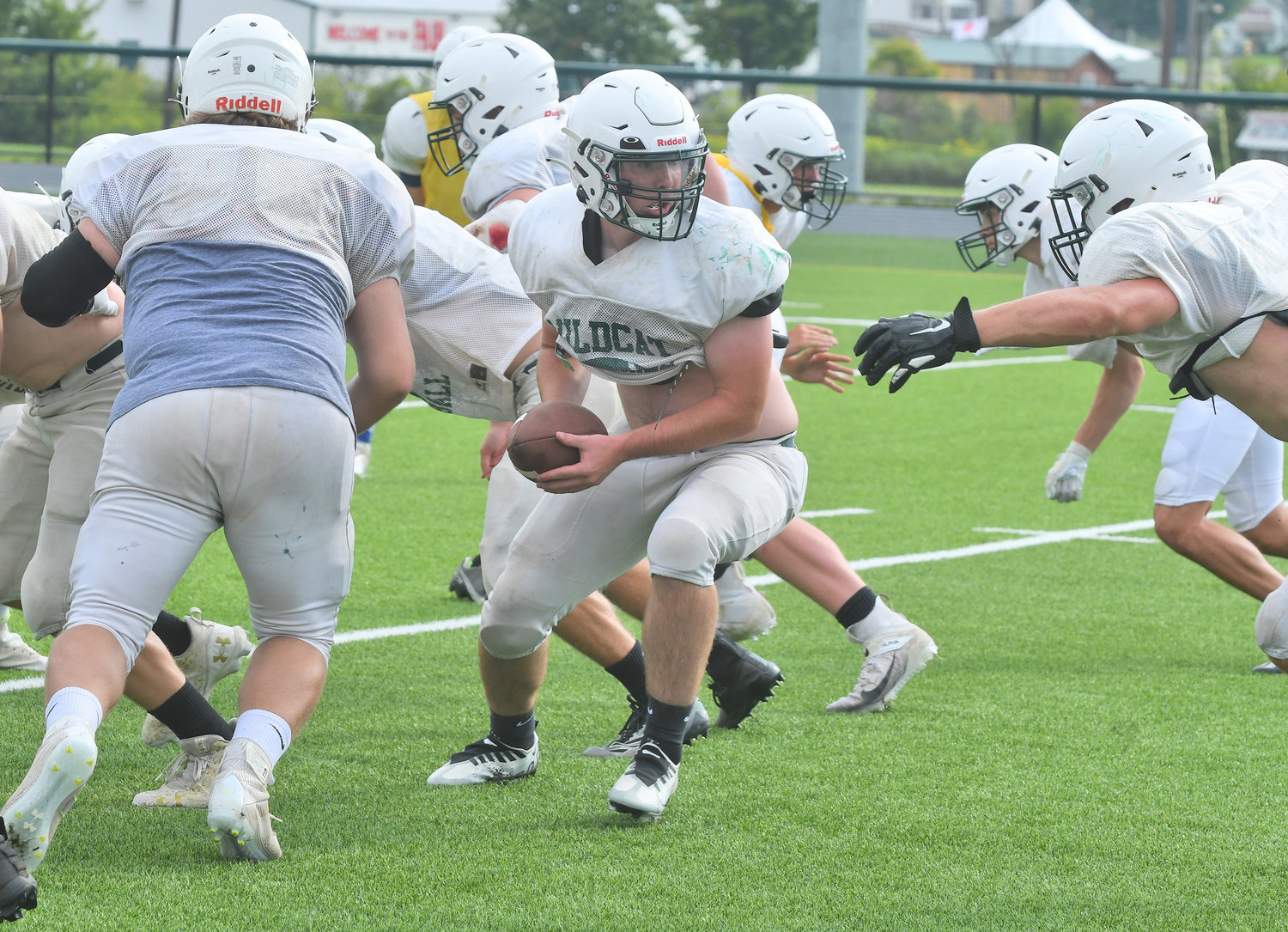 Adirondack quarterback Brett Sanford turns to hand the ball off to Colin White with offensive lineman Brandon Moore pulling for a block during at recent practice in Boonville. Sanford and White are top returners for the Wildcats.