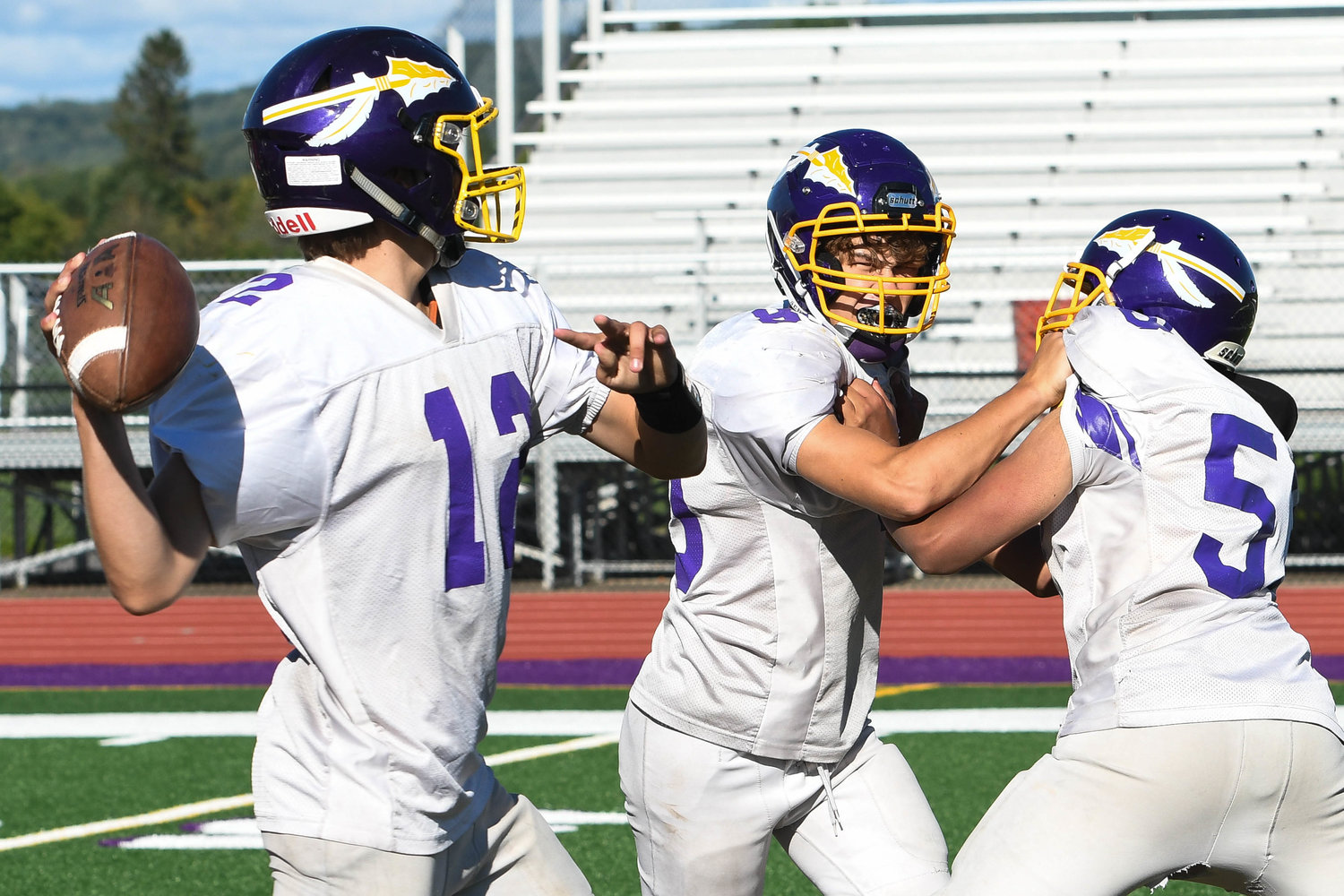 Waterville player Tyler Evans, center, rushes quarterback Kane Patterson during practice. The Class D team opens the season against visiting Mount Markham.
