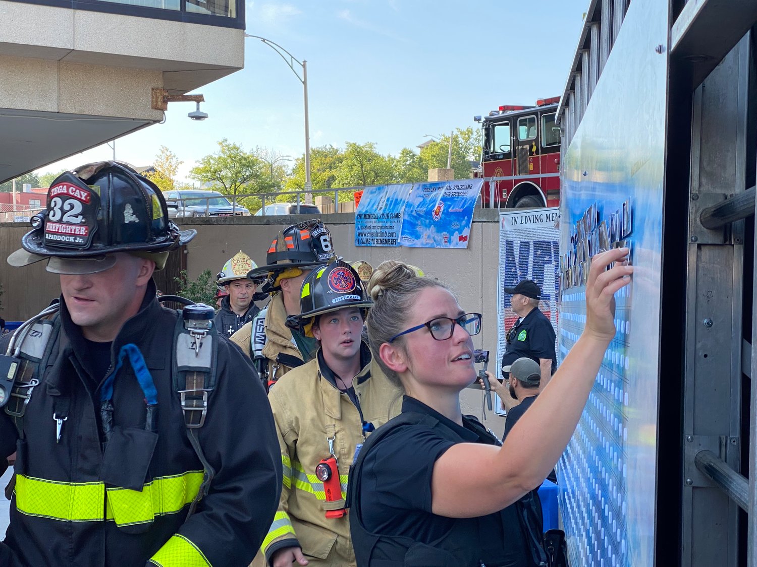 A first responder completes the Central New York Memorial Stair Climb and places the name and photo of a person who passed away during 9/11 on the memorial wall.