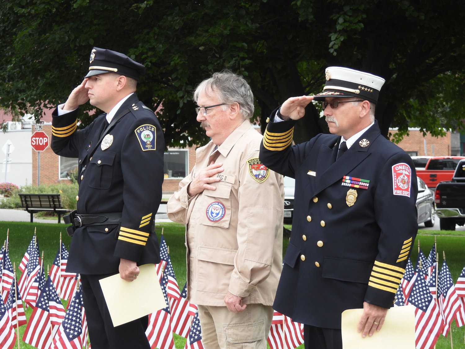 Oneida Police Chief John Little, left, former Madison County Undersheriff Douglas Bailey, and Oneida Fire Chief Dennis Fields stand at attention for the wreath laying ceremony on Sunday at the city's 9/11 Remembrance Ceremony.