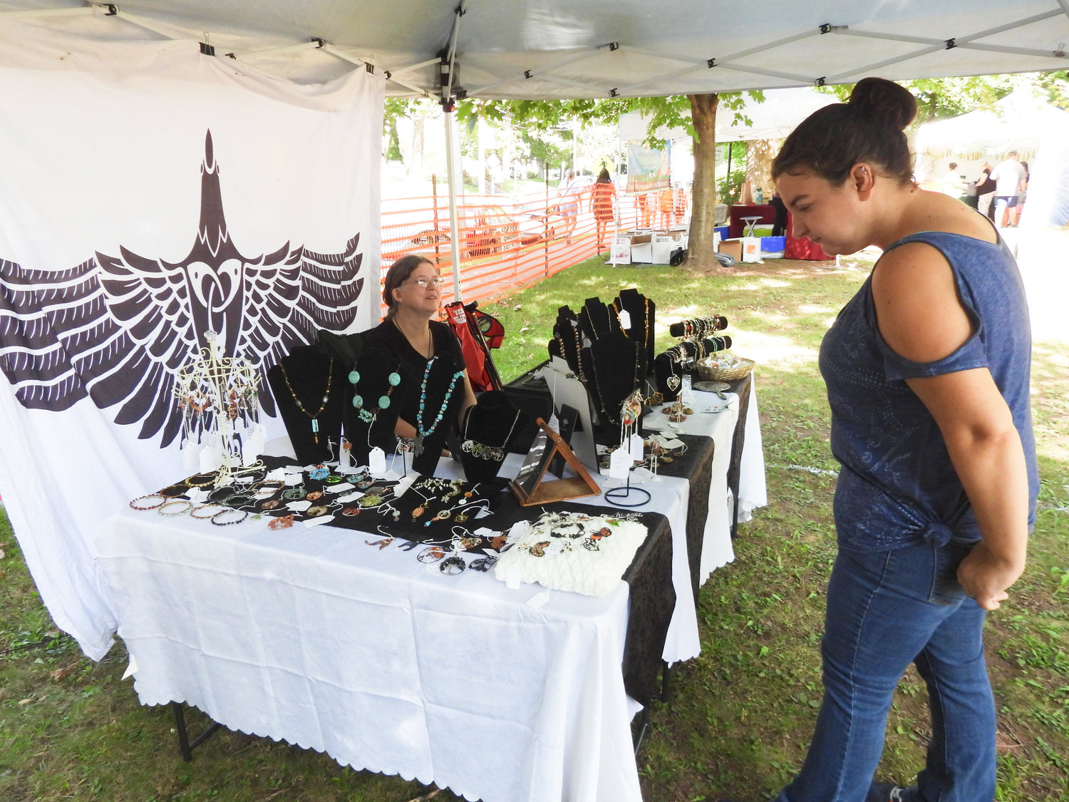 Lisa Fish, left, a resident of Oneida and owner of Magpie Mercantile, sells her handmade jewelry at the 58th Annual Madison County Craft Festival in Oneida, on Sept. 10, 2022.
