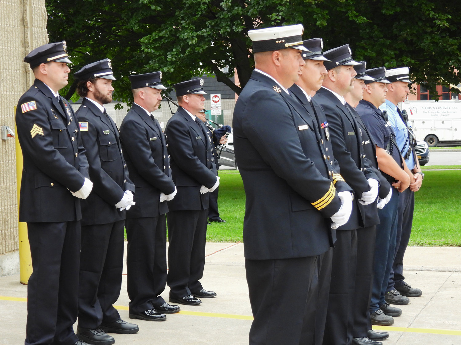Members of the Oneida Fire Department and Police Department stand at attention, honoring and remembering those that lost their lives during 9/11.