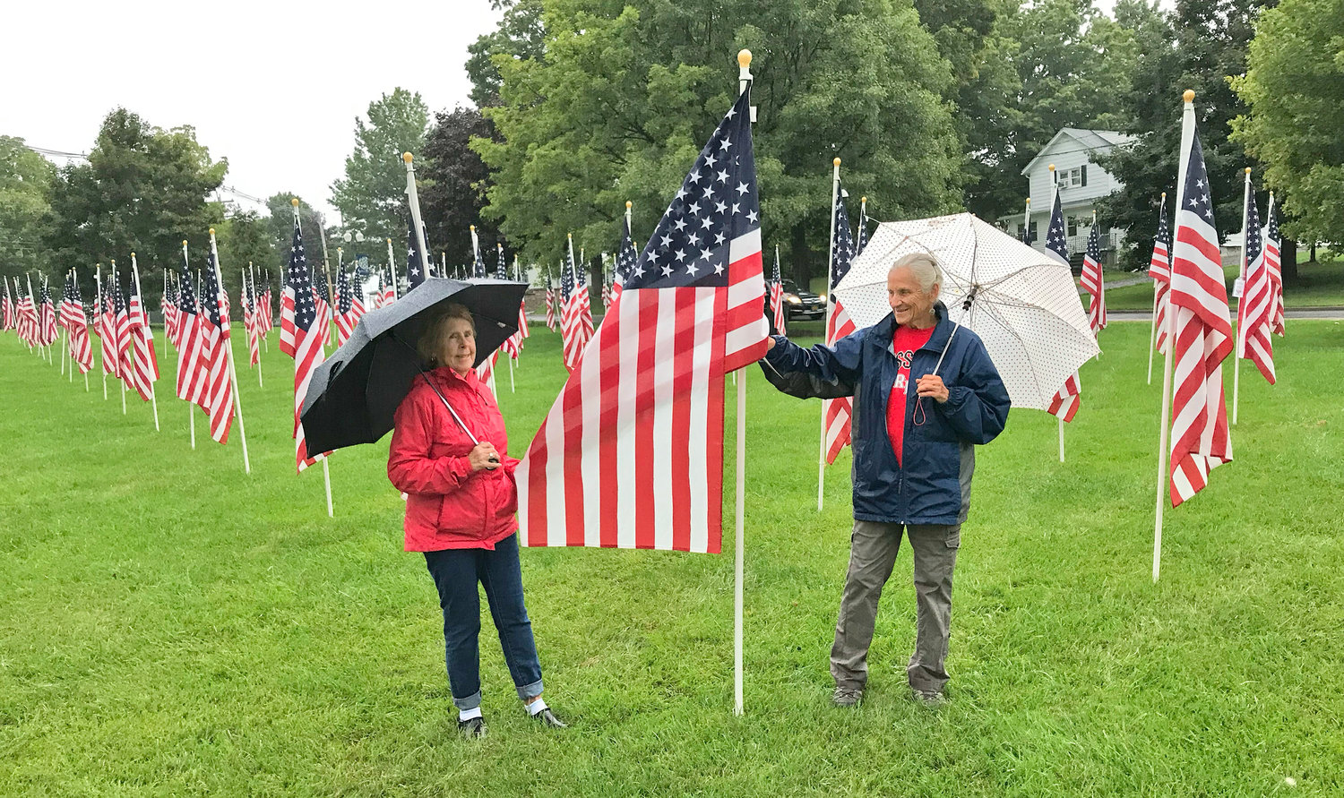 Rose Hatch, left, and Suzanne Adams-LaLonde walk through the American flags Sunday during the 9/11 Remembrance Ceremony at Reilly-Mumford Park in Sherrill.