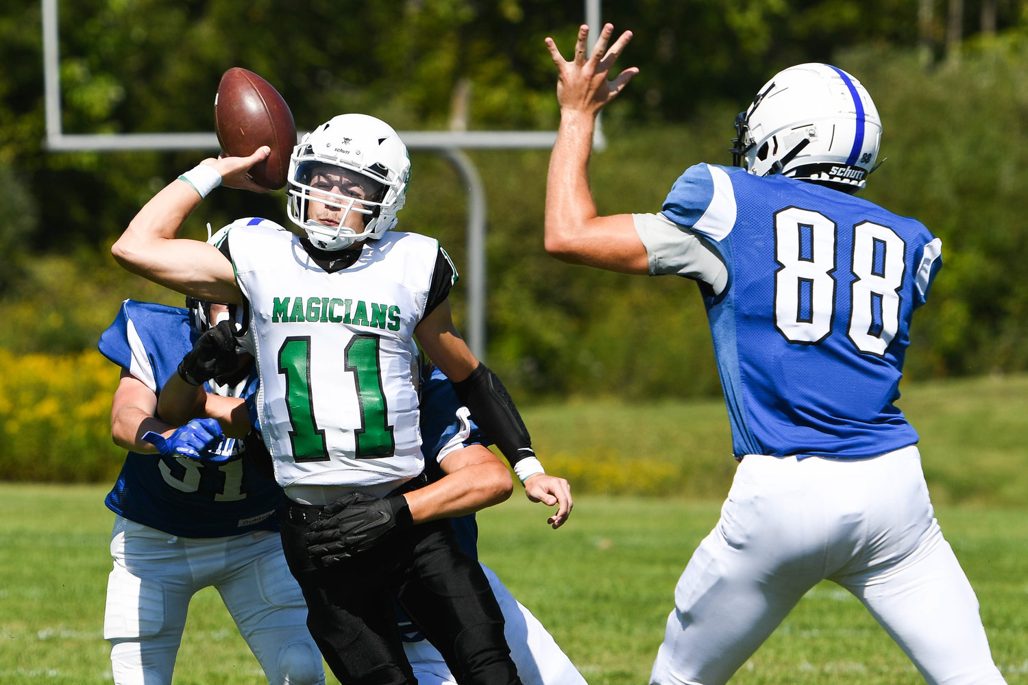 Herkimer quarterback Nick Caruso (11) is hit by Dolgeville defenders while throwing during the game on Saturday.