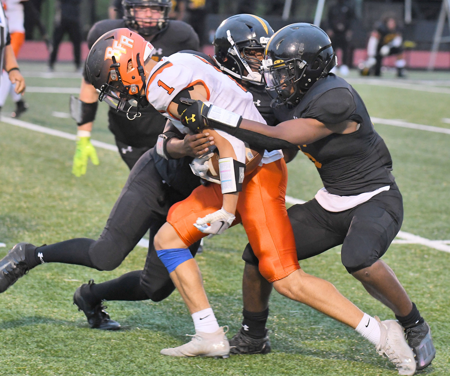 Rome Free Academy senior receiver Jack Lawless gets wrapped up by Henninger defenders Friday night. Lawless was busy in the team's 21-20 win, making 10 catches for 144 yards and a score.