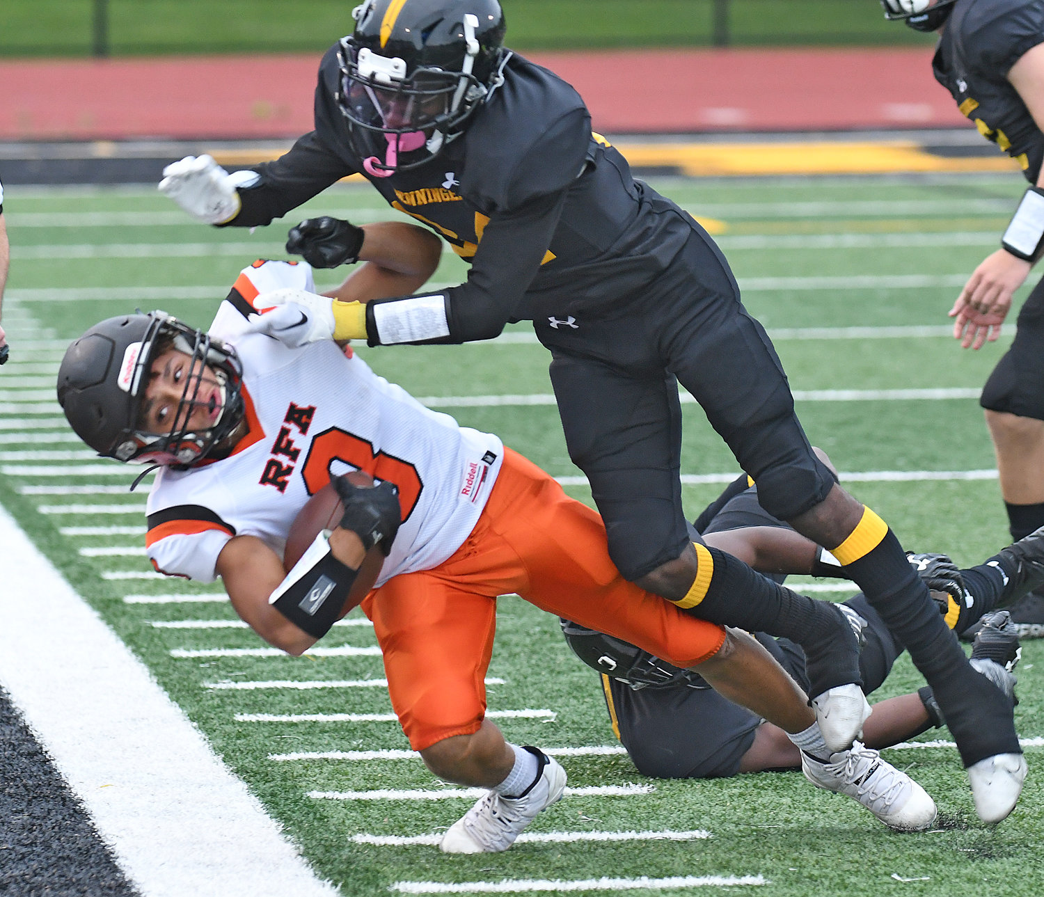 Rome Free Academy receiver Lebron Bowman gets toppled out of bounds by Henninger's Luis Madero-Williams in the first quarter of Friday's game. RFA got a 21-20 road win. Bowman's 55-yard catch and run for a touchdown was the game-winning TD.