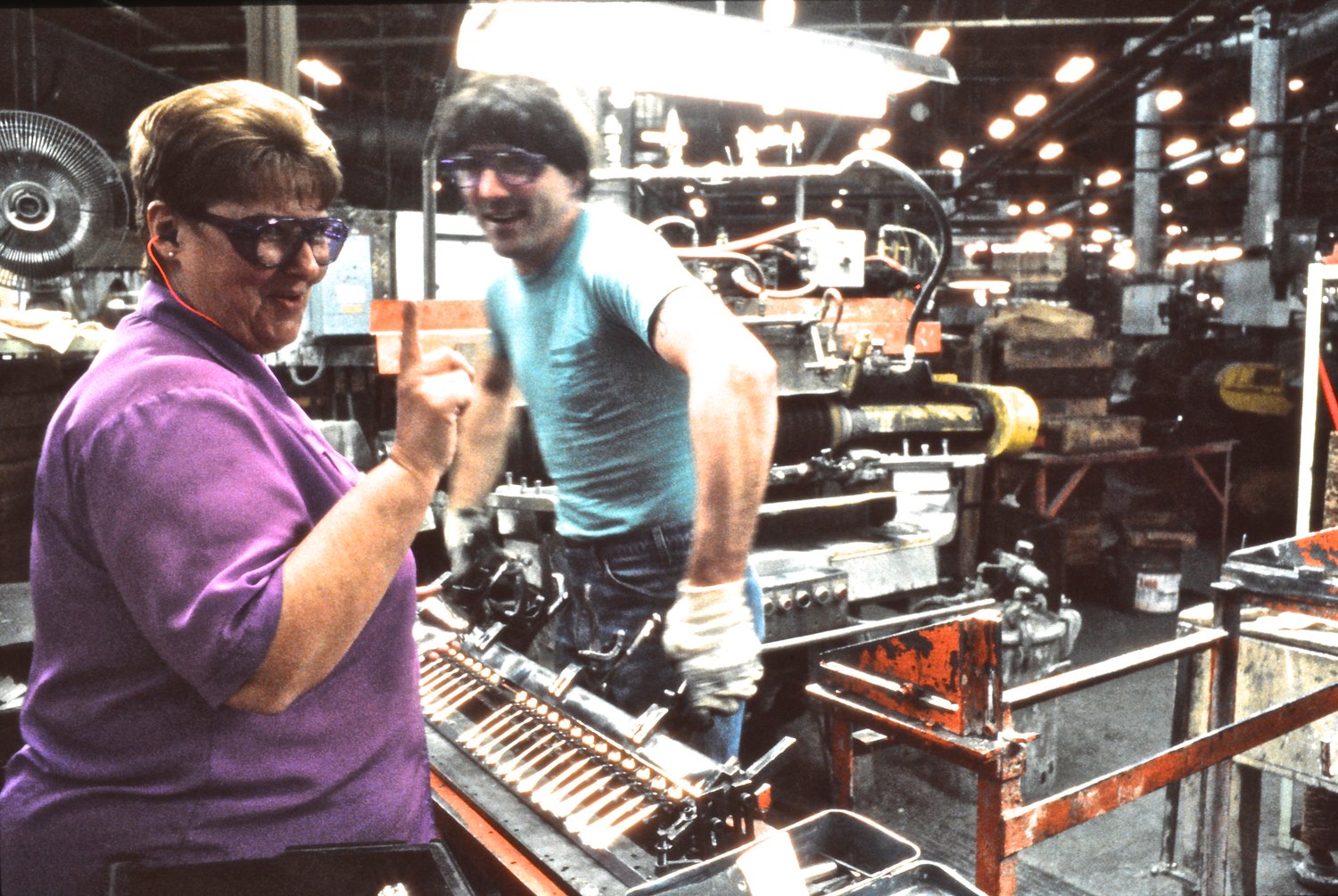 Two Oneida Limited employees prepare a rack of spoons for buffing.