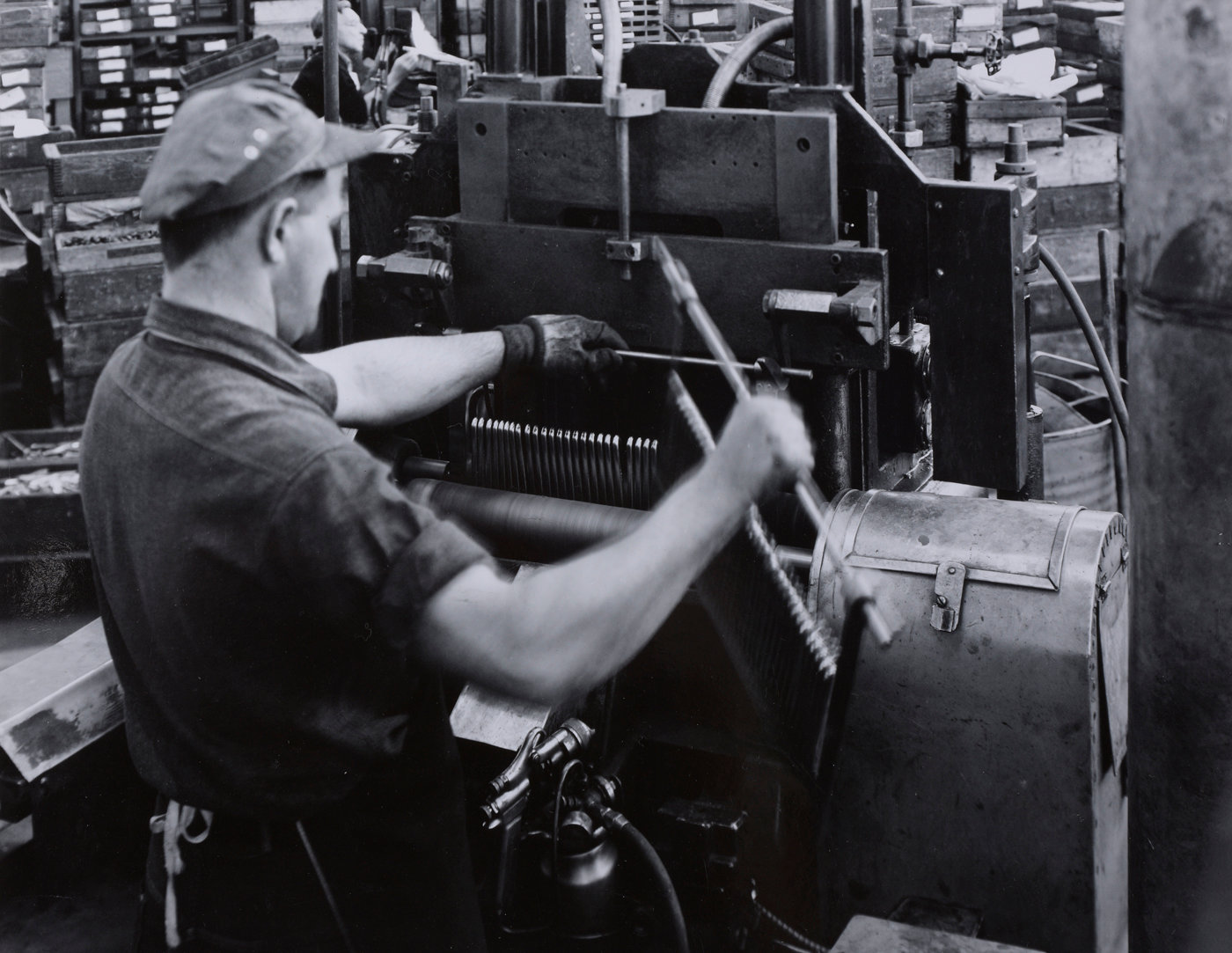 An Oneida Limited employee buffs a rack of knives. Estimated date of photo is 1950s.