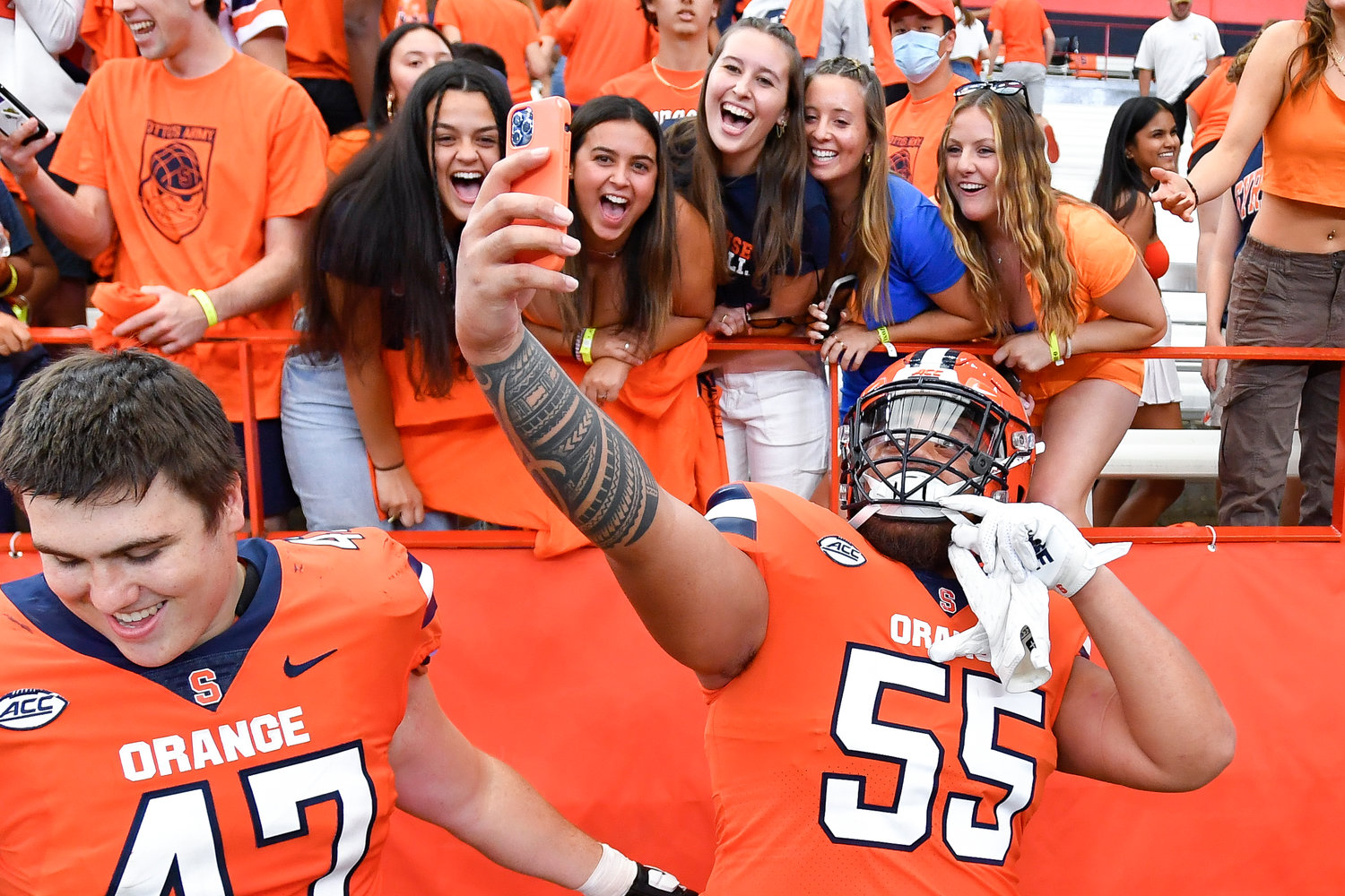Syracuse offensive lineman Josh Ilaoa (55) takes a selfie with fans after beating Purdue in an NCAA college football game in Syracuse, N.Y., Saturday, Sept. 17, 2022. Syracuse won 32-29.