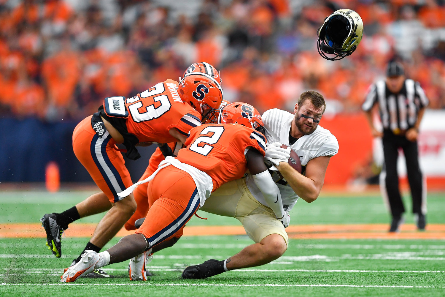 Purdue tight end Payne Durham, right, loses his helmet while being tackled by Syracuse linebacker Marlowe Wax (2) and defensive back Justin Barron (23) during the first half of an NCAA college football game in Syracuse, N.Y., Saturday, Sept. 17, 2022.