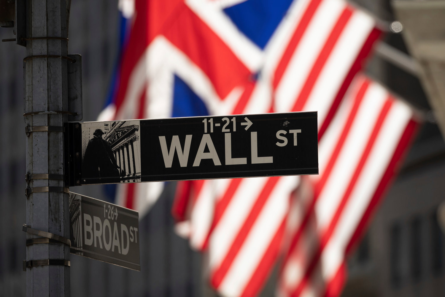 A Wall Street sign hangs in front of the New York Stock Exchange, Friday, Sept. 16, 2022, in New York.  Stocks fell broadly in afternoon trading on Wall Street Friday, putting the market on track for another week of sizable losses.