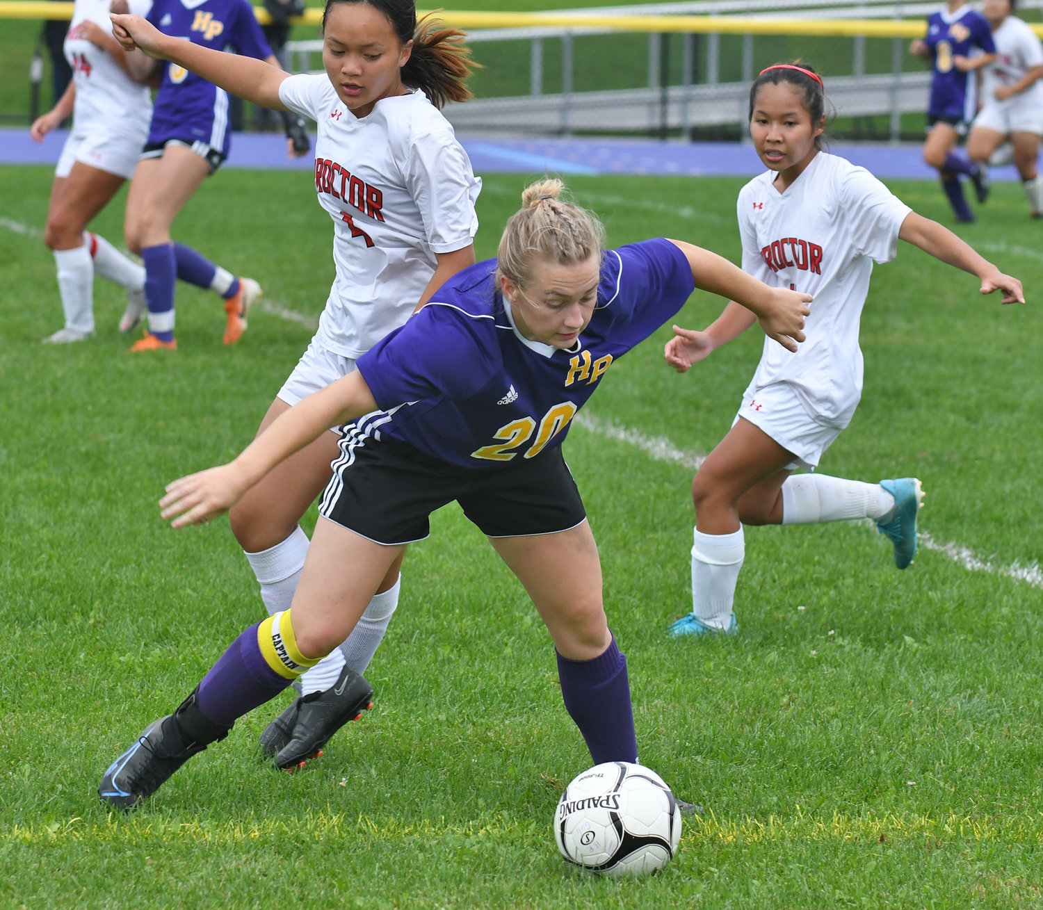 Proctor’s Kimani Thomas gets blocked out by Holland Patent’s Stephanie Grocholski during the first half Tuesday at Holland Patent. Proctor’s Nancy Shine is in the background. Grocholski had an assist in the Golden Knights’ 2-0 win.