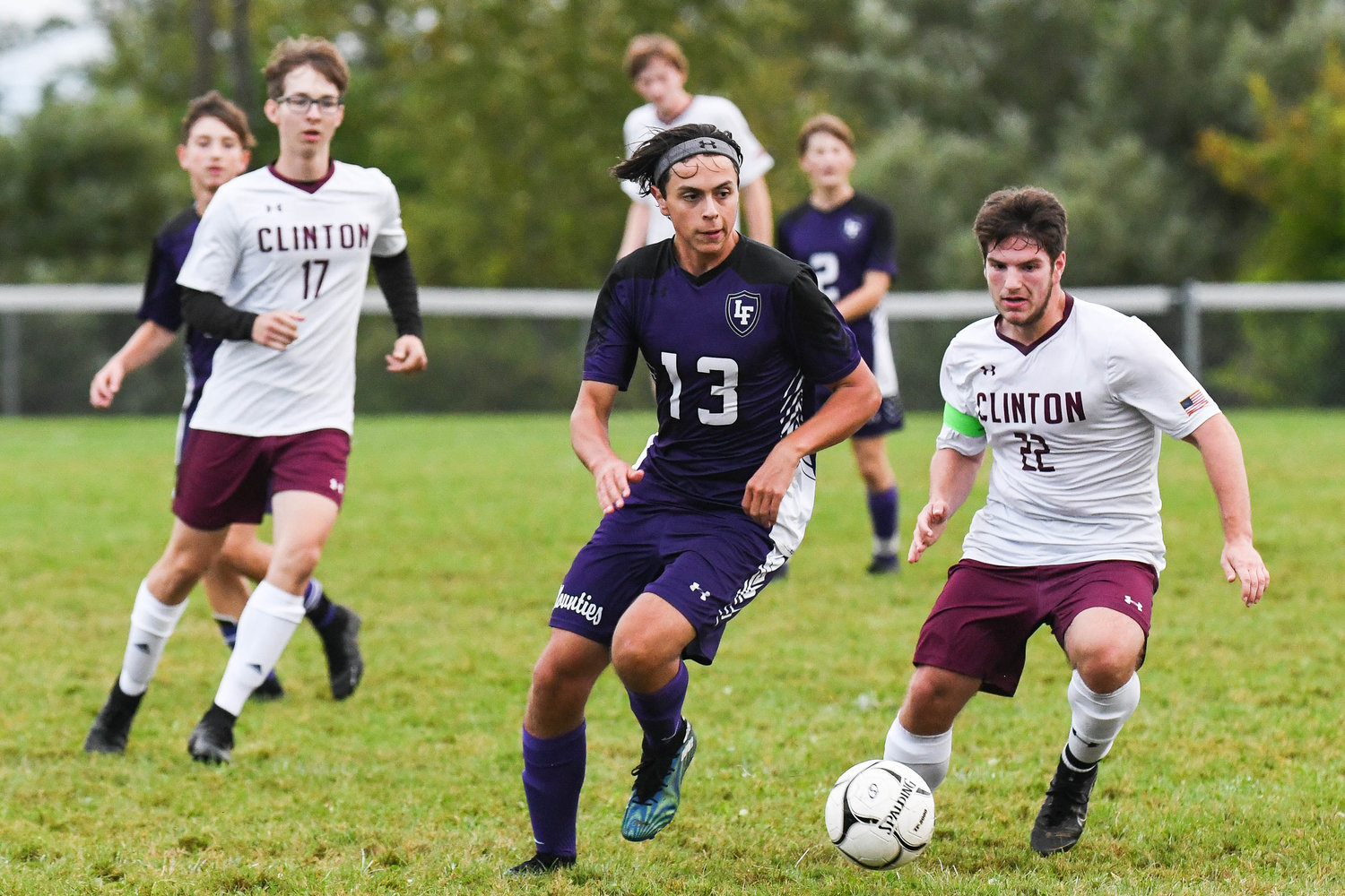Little Falls player Sean Carroll, center, fights for control of the ball with Clinton's Joseph Frank, right, during the game on Tuesday. Little Falls won 3-1.