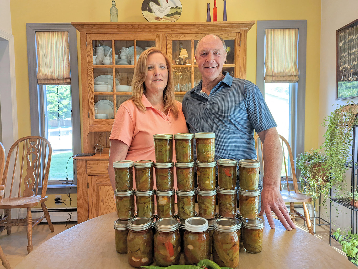 Shelley and Chuck DelMonte proudly survey this year's stock of their signature canned long hot and cubanelle peppers in their Whitesboro home.