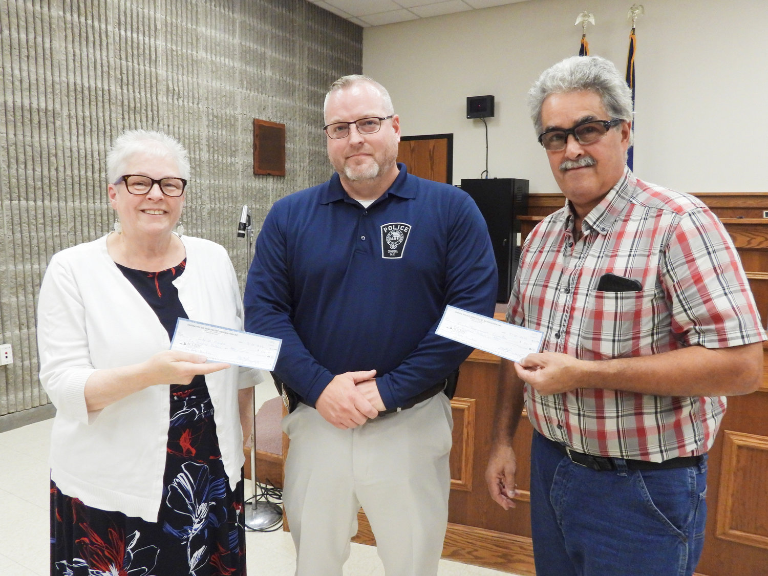At the Tuesday, Sept. 20 meeting, Oneida Police Sgt. Mike Burgess, center, presents Oneida Improvement Committee President and Supervisor Joseph Magliocca with a check for $500 to help fund the Oneida Cat Committee’s efforts to trap, neuter, and release; $500 was also presented to Mayor Helen Acker to go towards construction of the new dog park in Oneida.