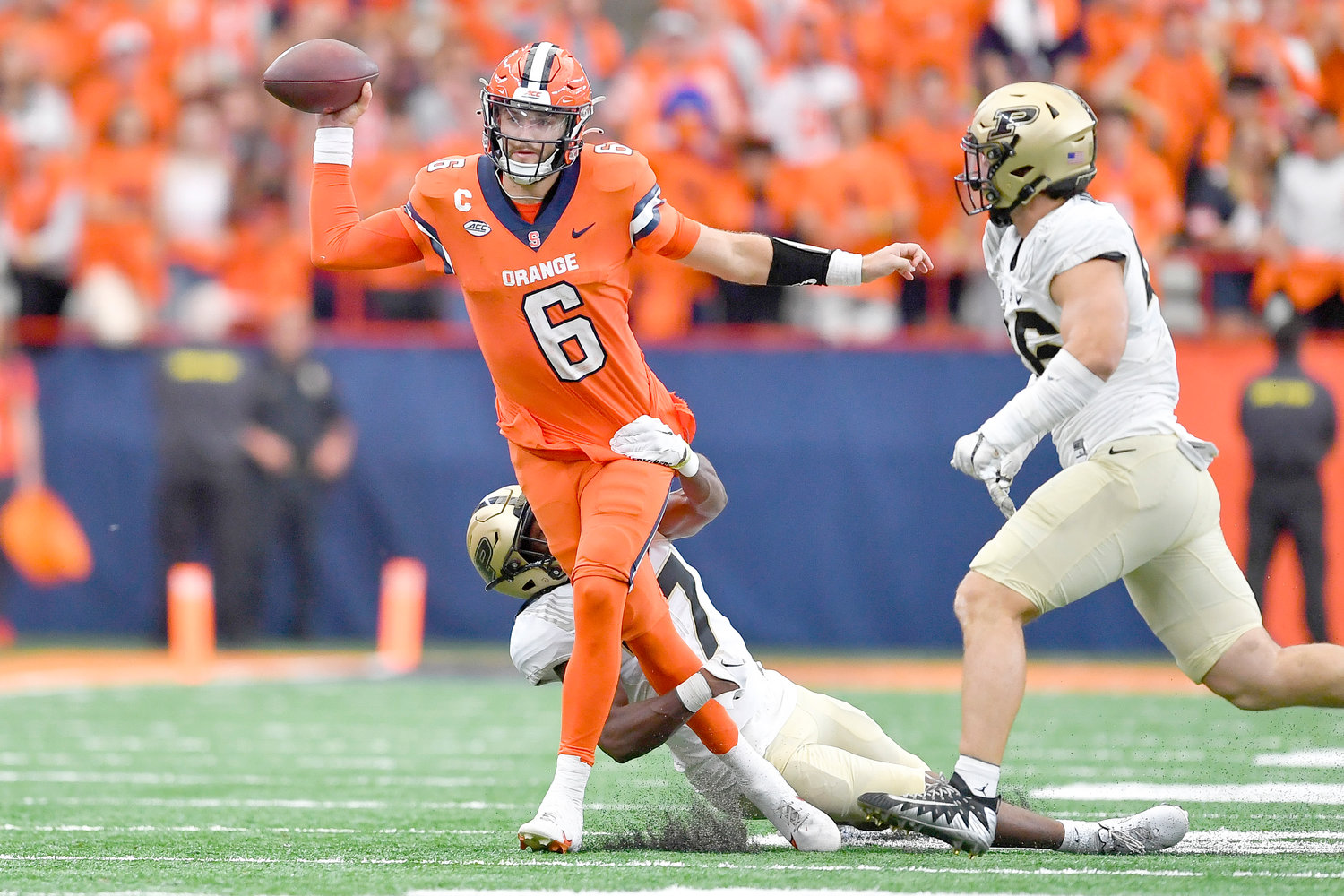 Syracuse quarterback Garrett Shrader, left, throws the ball while pressured by Purdue safety Chris Jefferson during Saturday’s non-league game in Syracuse. The Orange won 32-29.