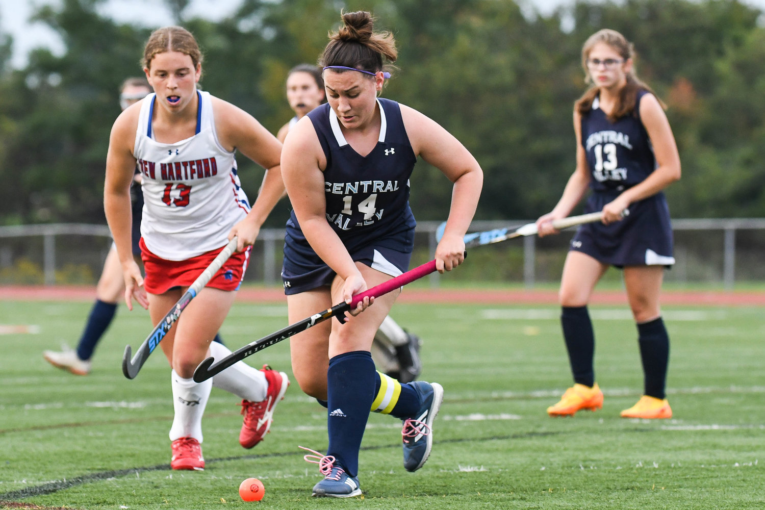 Central Valley Academy player Samantha Helmer (14) moves the ball against New Hartford player Sienna Holmes during the field hockey game on Wednesday.