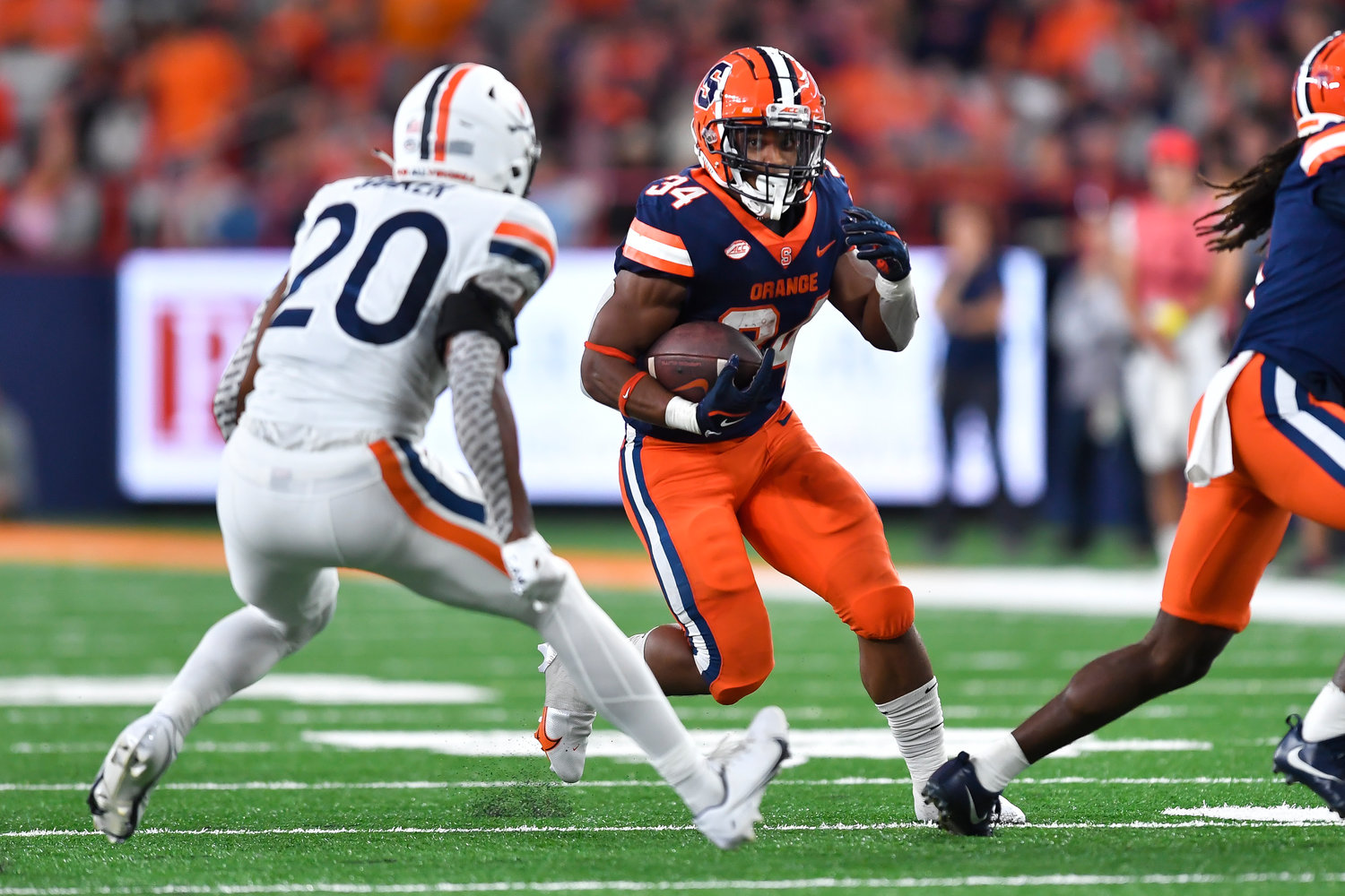 Syracuse running back Sean Tucker (34) runs with the ball while pressured by Virginia safety Jonas Sanker (20) during the first half on Friday night in Syracuse.