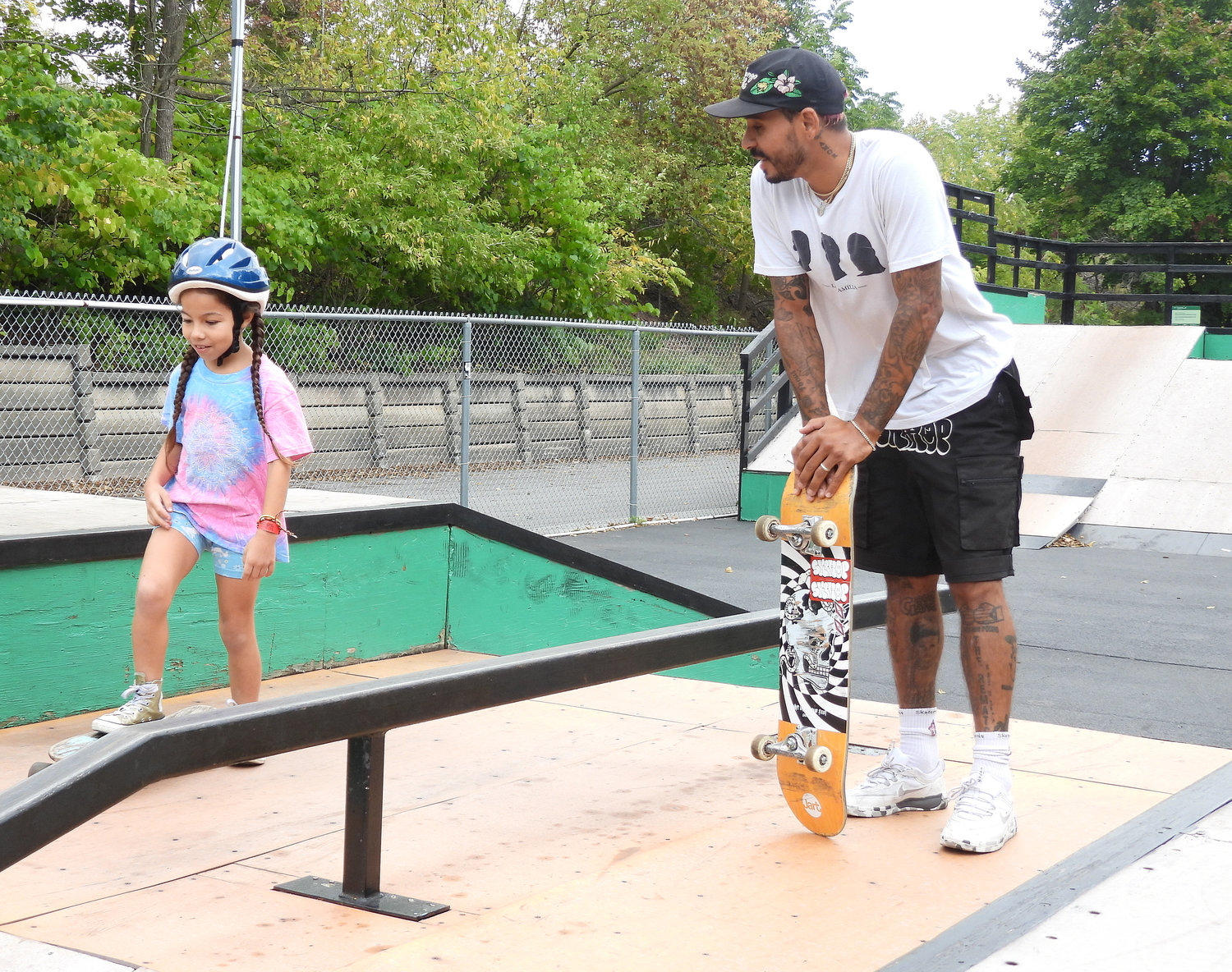 Emanuel "Manny" Santiago, Olympian and professional skateboarder, visited the Lenox Skatepark for a meet and greet, where he shredded the pipes and took time to give pointers and lessons to young children still learning their way around the board. Pictured here, Santiago instructs a young girl before she heads down the ramp, reminding her to shift her balance and to push off to get more speed before she goes up the next ramp