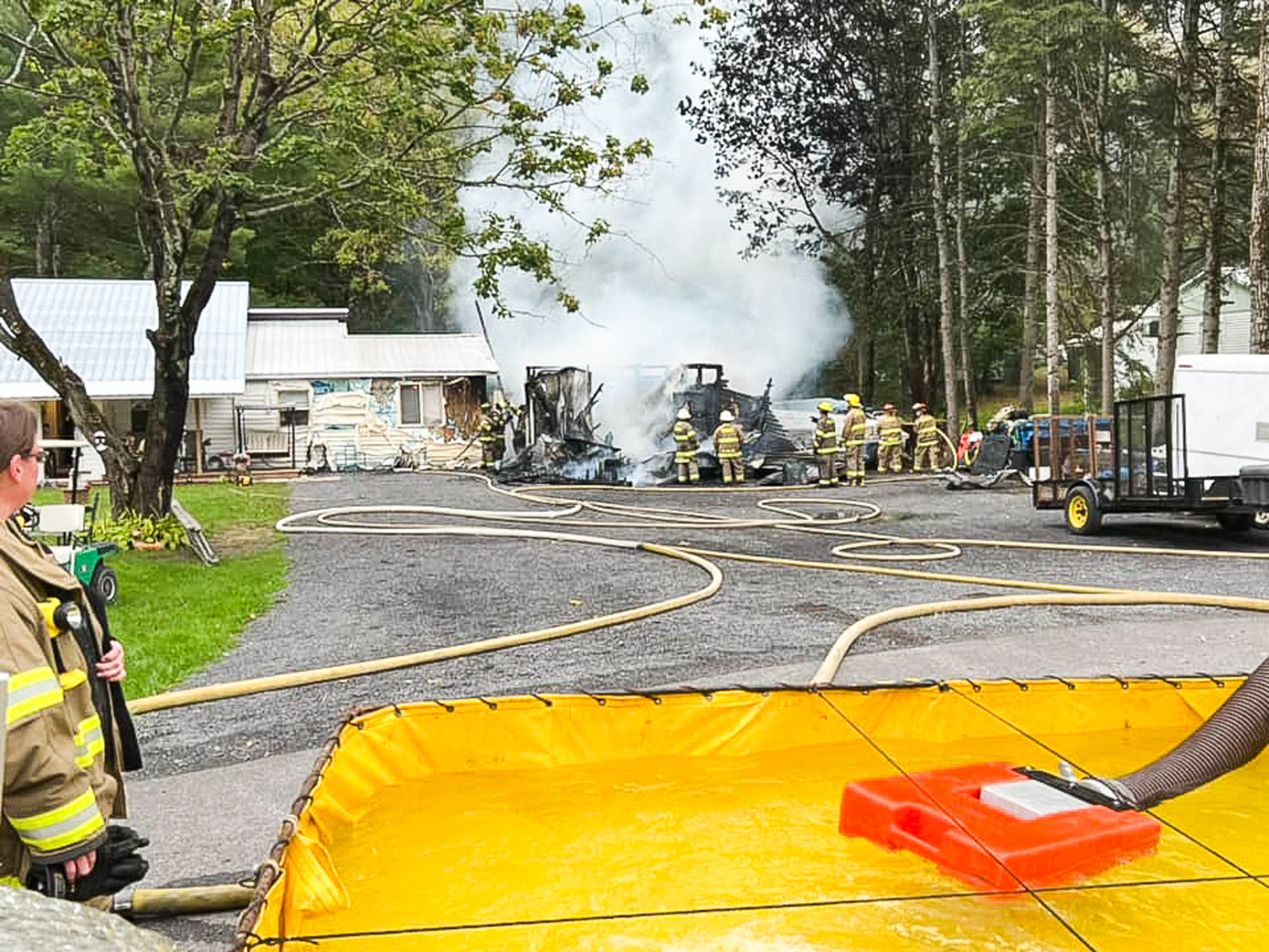 Volunteer firefighters work to douse a garage fire in Remsen Wednesday afternoon. Fire officials said no one was injured and the residence was saved.