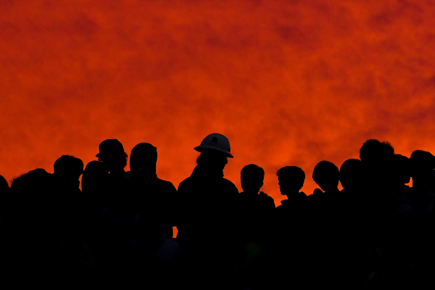 The sun sets behind New Hartford students in the bleachers during the game against Whitesboro on Friday night.