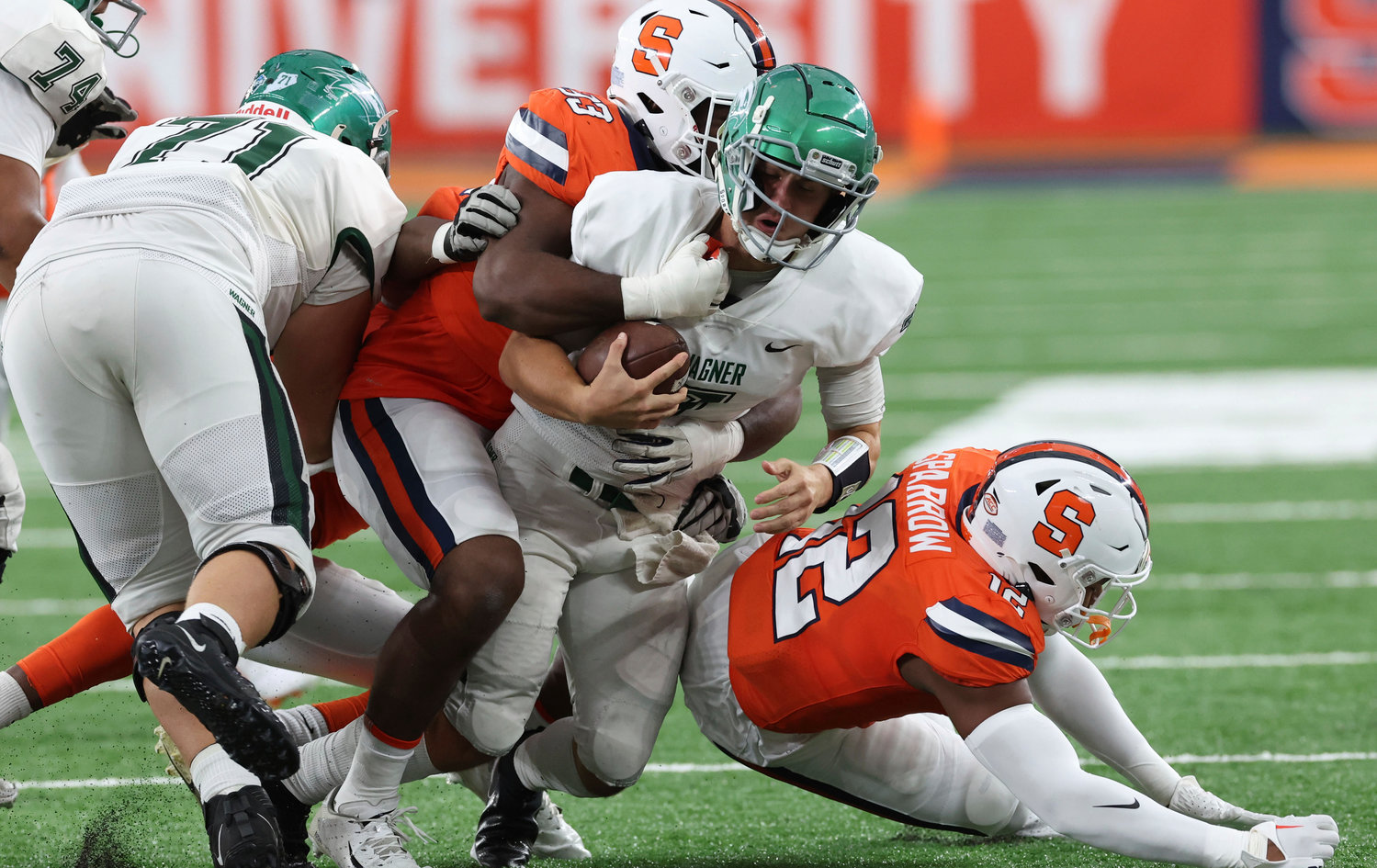 Wagner quarterback Ryan Kraft (7) is brought down behind the line of scrimmage by Syracuse defenders during a game Saturday in Syracuse.