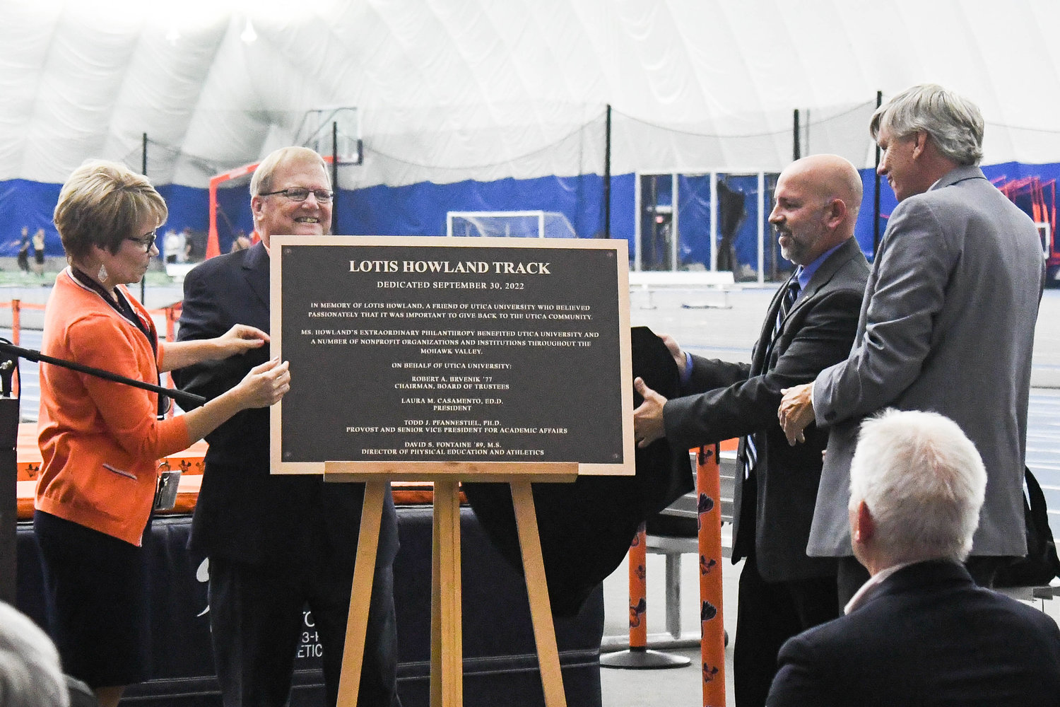 A plaque is revealed during a dedication ceremony for the Lotis Howland Track on Friday at the Todd and Jen Hutton Sports & Recreation Center at Utica University. The plaque, which was unveiled by Utica University President Laura Casamento and Director of Athletics and Physical Education Dave Fontaine, was dedicated in memory of Howland. The plaque says "he was a friend of Utica University who believed passionately that it was important to give back to the Utica community.