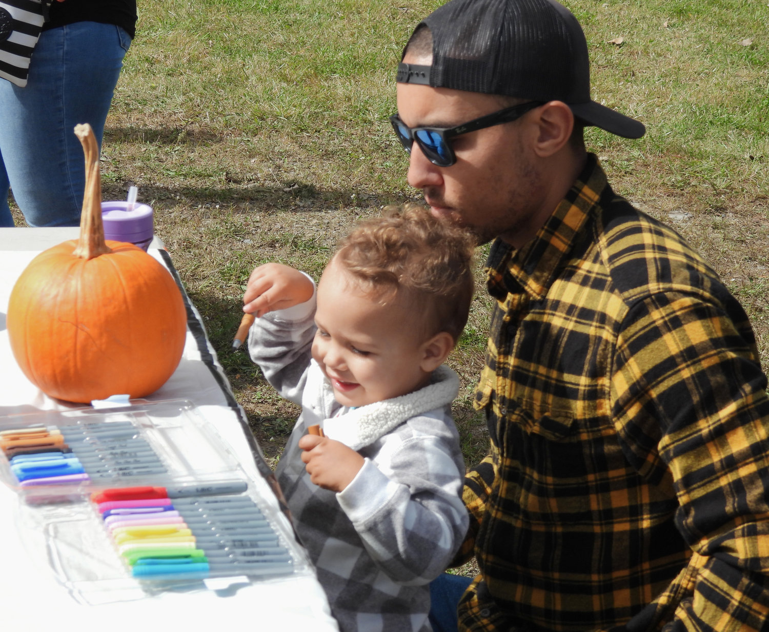 Rome resident Anthony Jones helps two-year-old Amelia Jones decorate her pumpkin at the Oneida Fall Fest on Saturday, Oct. 1 in the city of Oneida.