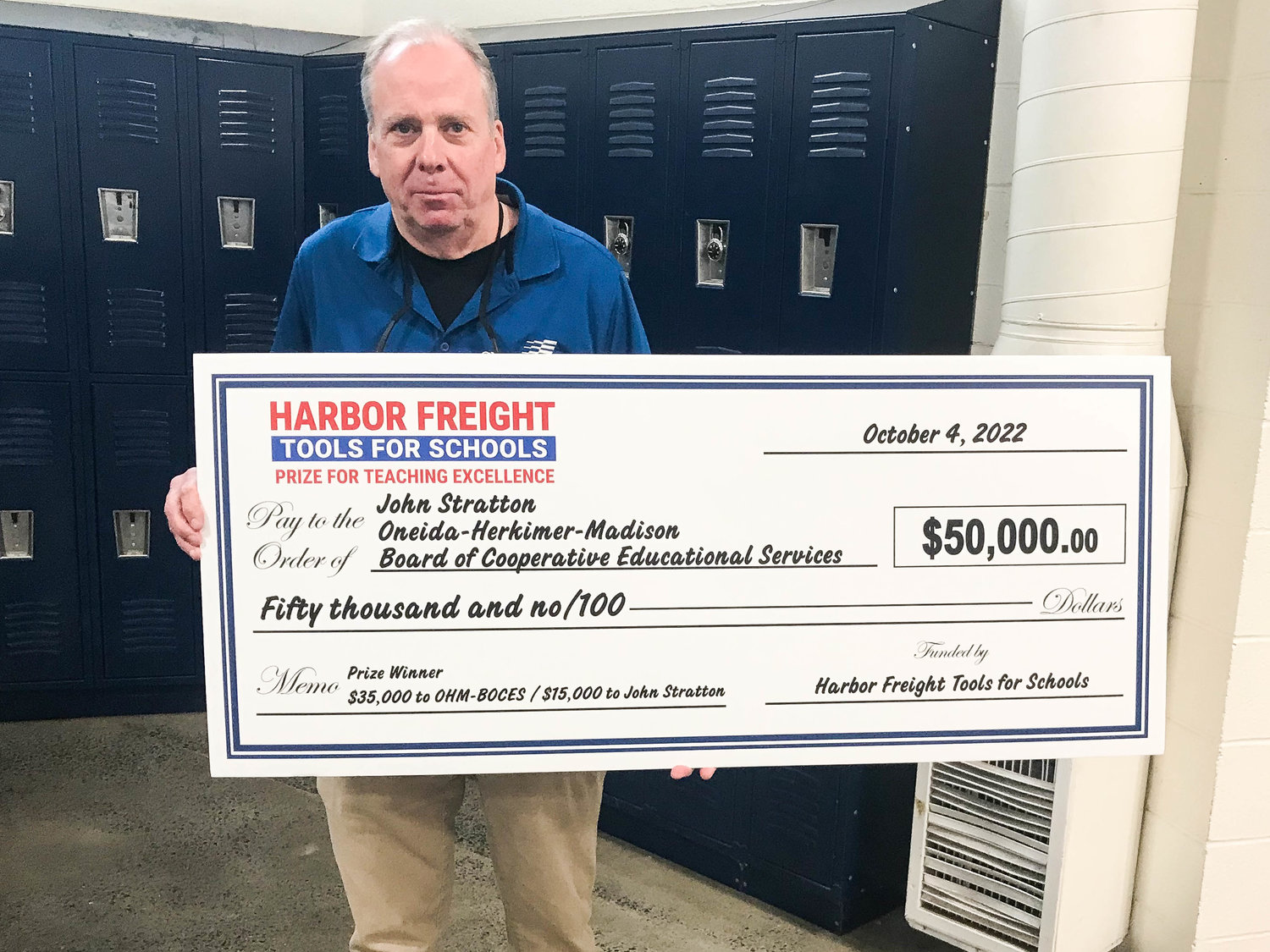 Automotive technology teacher John Stratton holds the $50,000 ceremonial big check presented to him Tuesday by Harbor Freight District Manager David Zinicola at Oneida-Herkimer-Madison BOCES in New Hartford.