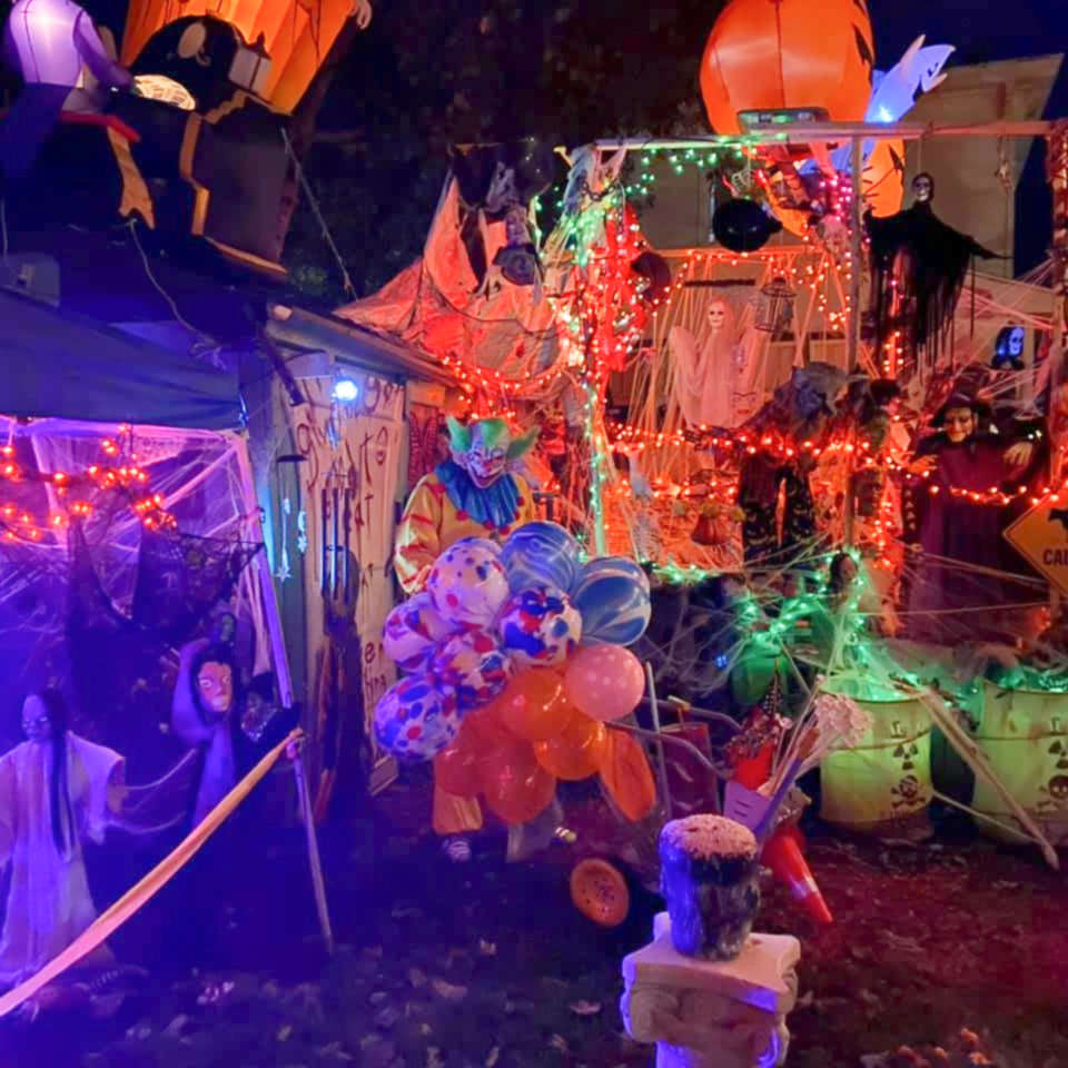 Earl Scribner, in costume, stands in his backyard amid his spooky Halloween display, which took first place in last year’s Oneida Halloween Light Fight.