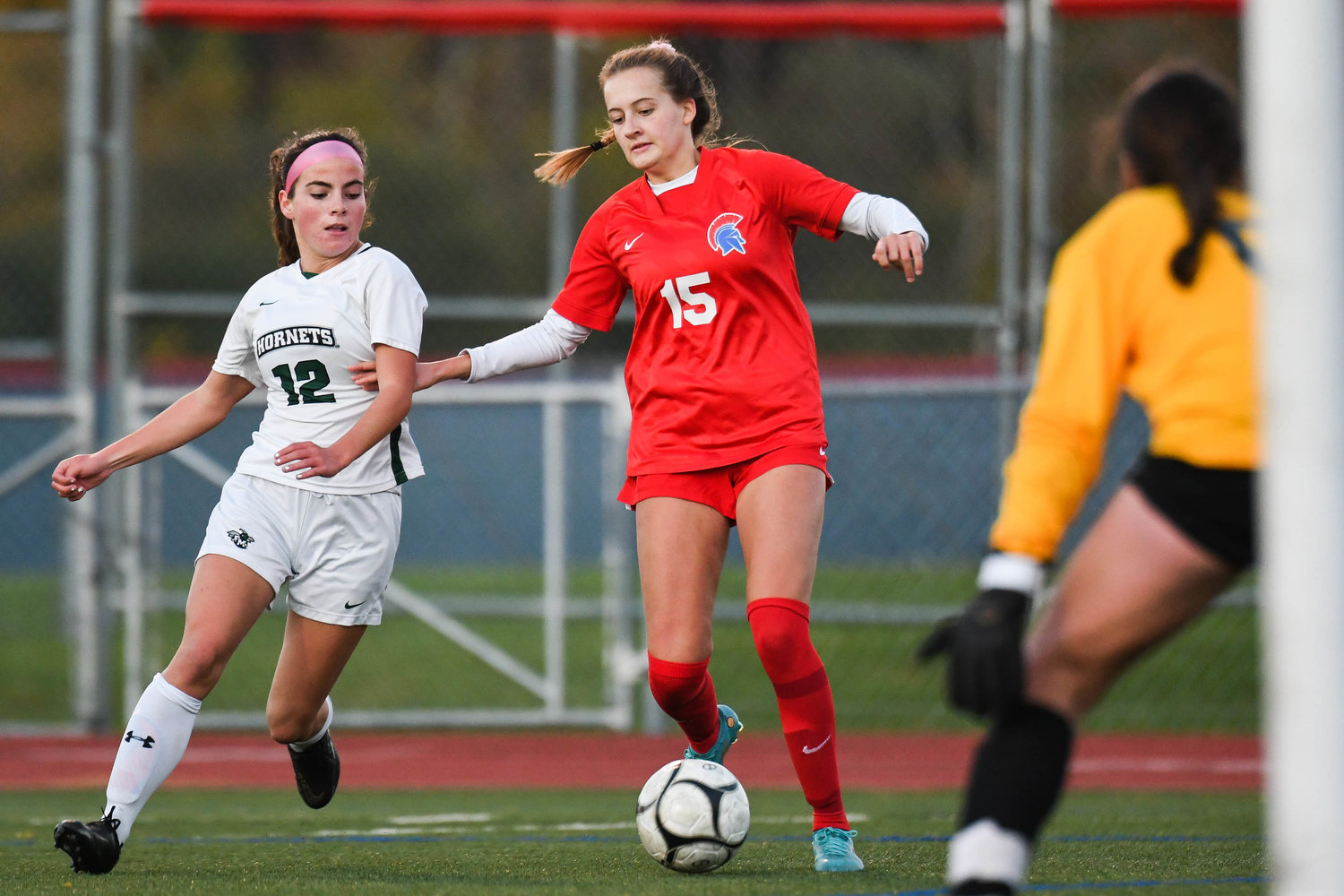 New Hartford’s Anna Rayhill moves the ball toward the net against Fayetteville-Manlius’ Sophia Leonard, left, during the game on Monday night in New Hartford. Rayhill scored twice and New Hartford won 4-0 on Senior Night, when nine players including Rayhill were honored.