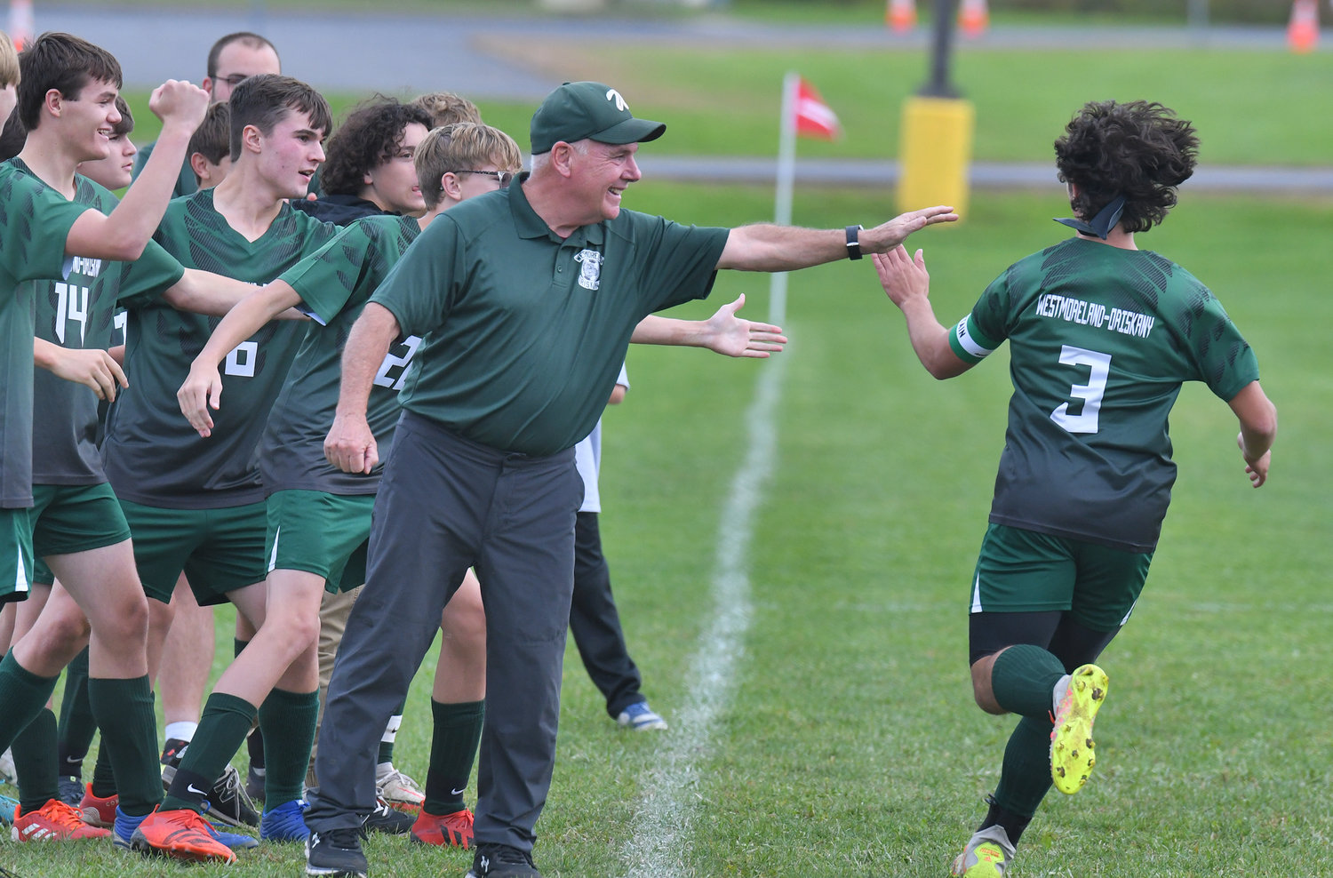Westmoreland/Oriskany's Jesse Sweet celebrates with the team after scoring the first goal of the game Wednesday afternoon at home against Clinton. Sweet scored again in the second half to break a tie and help the Bulldogs to a 2-1 win. Head coach Gil Palladino is at center.