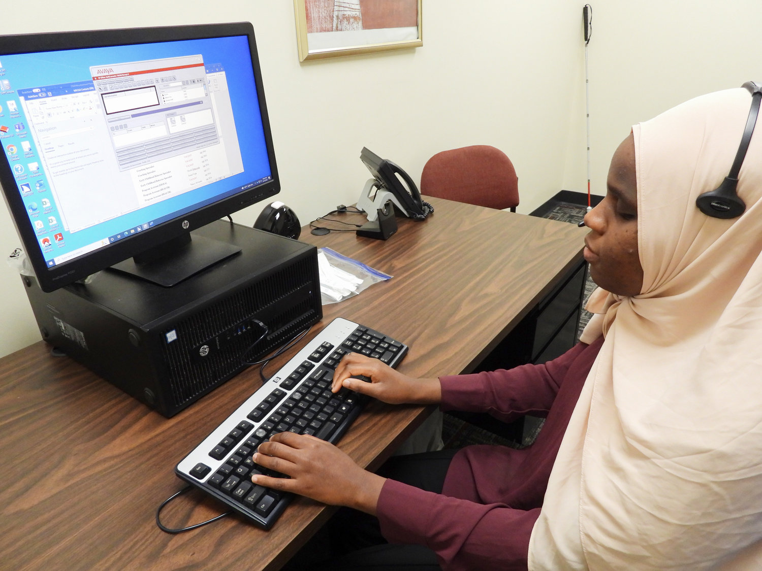 Makka Djouma, a Sudanese immigrant refugee who’s blind, works at the Mohawk Valley Community Action Agency in Utica as a telephone operator and receptionist.(Sentinel photo by Charles Pritchard)