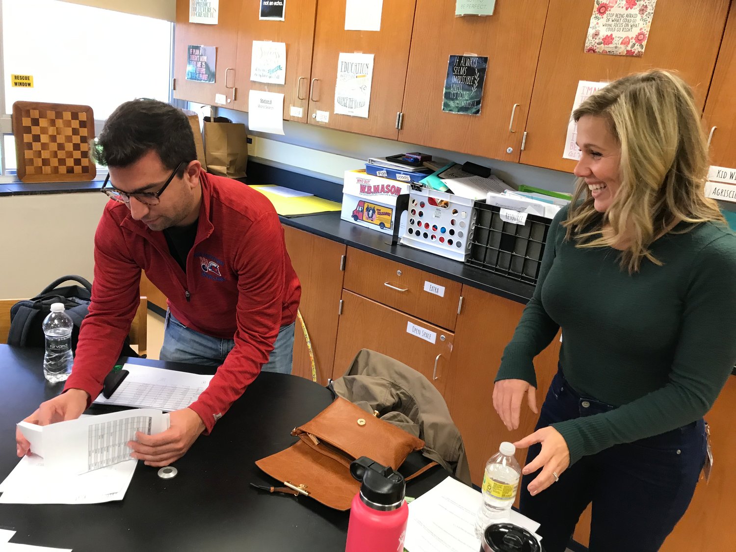 New Hartford Mathletics team co-advisors Matt Romanow and Carrie Tinker look over students' answer papers Saturday in the coaches' room at Hamilton Central School.