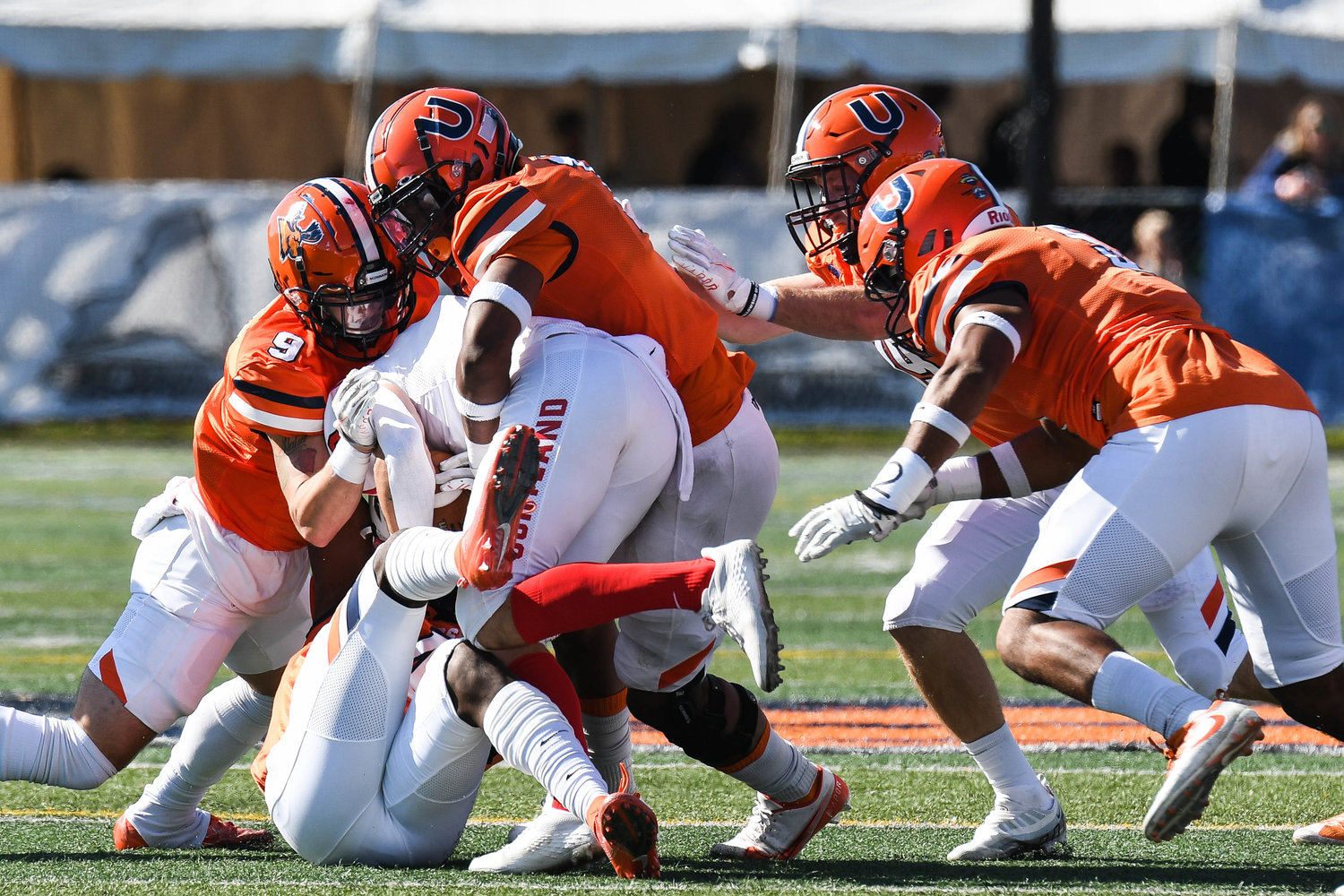 A group of Pioneers defenders make a tackle during the Empire 8 game against SUNY Cortland on Saturday afternoon at Charles A. Gaetano Stadium in Utica.