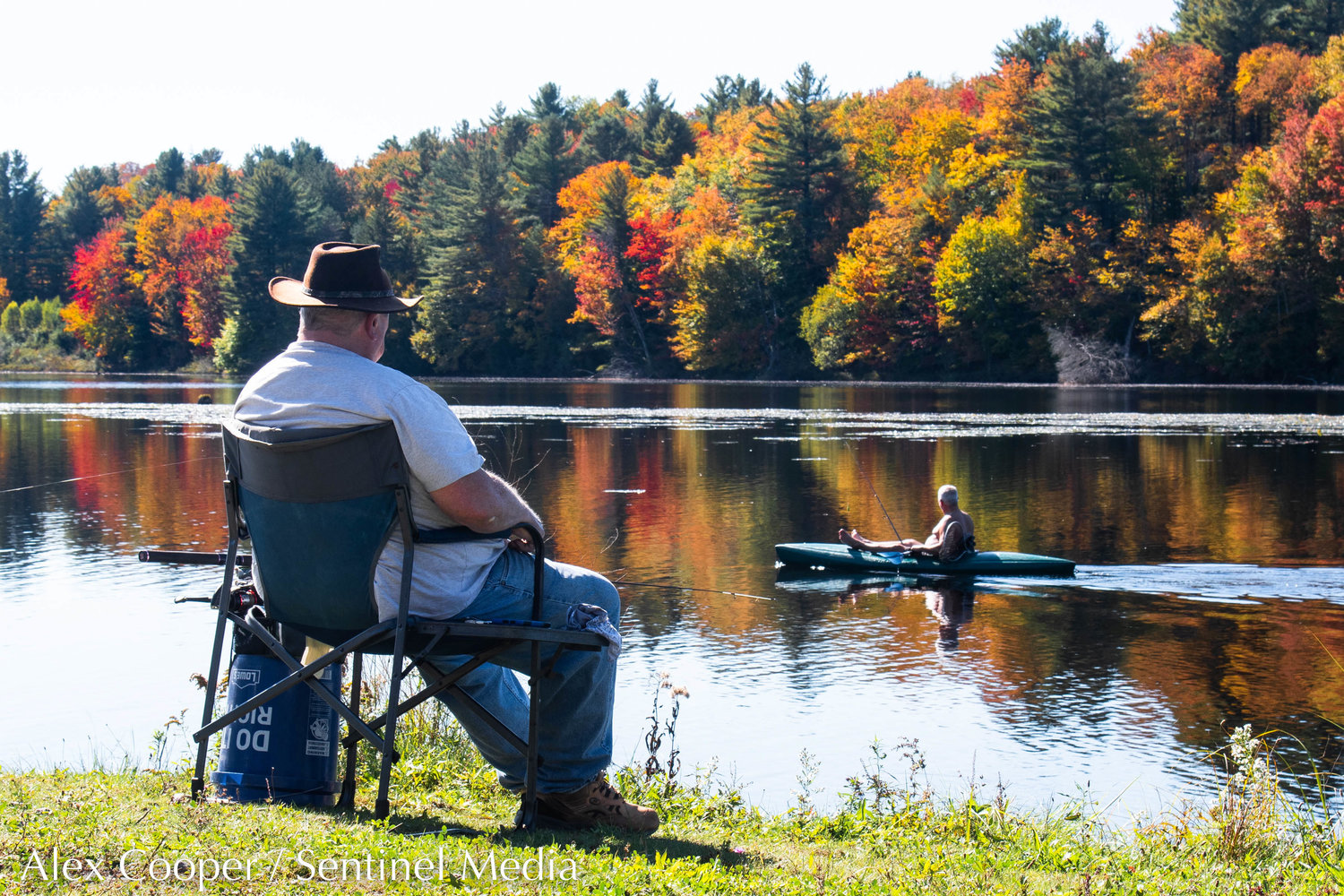 A kayaker paddles by as a man fishes at Forestport Reservoir on Wednesday, Oct. 5.