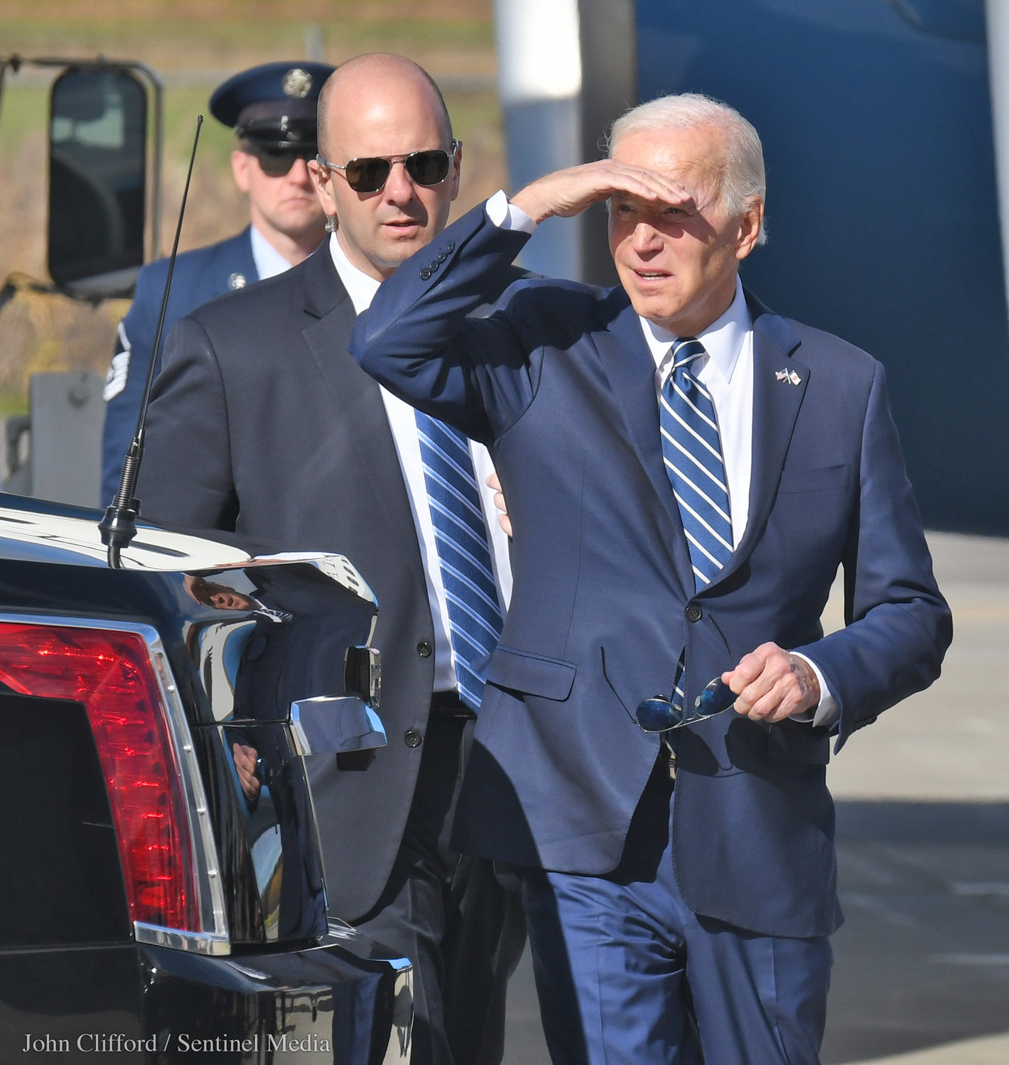President Joe Biden shades his eyes to look for the crowd of well wishers gathered at Hancock International Airport Thursday, Oct. 27, 2022.