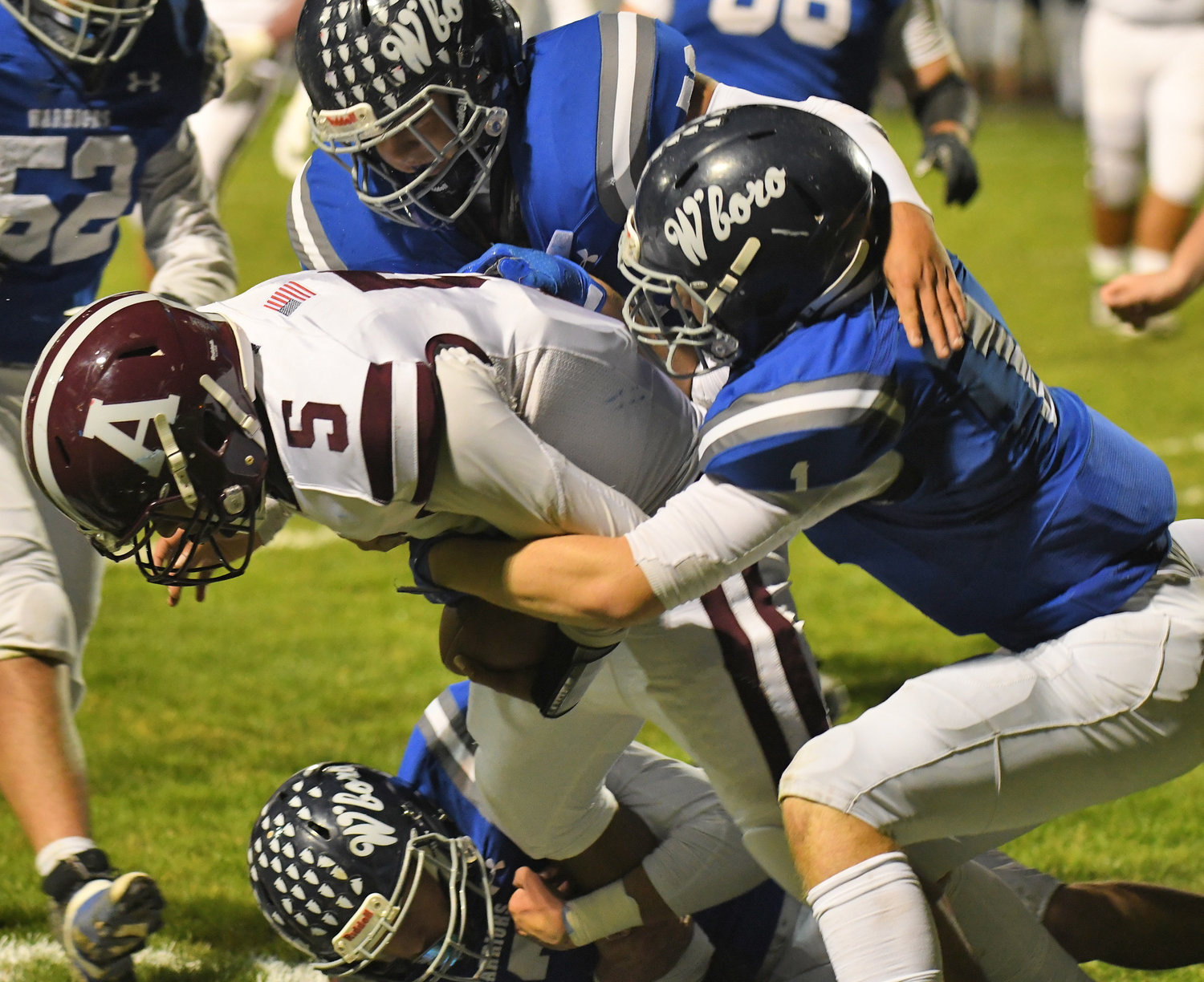 Whitesboro defenders Patrick Wands, right, and Vincent Zajac, top, tackle Auburn quarterback Elijah Scott in the first quarter Friday night in a Section III Class A quarterfinal. The host Warriors won 42-7.
