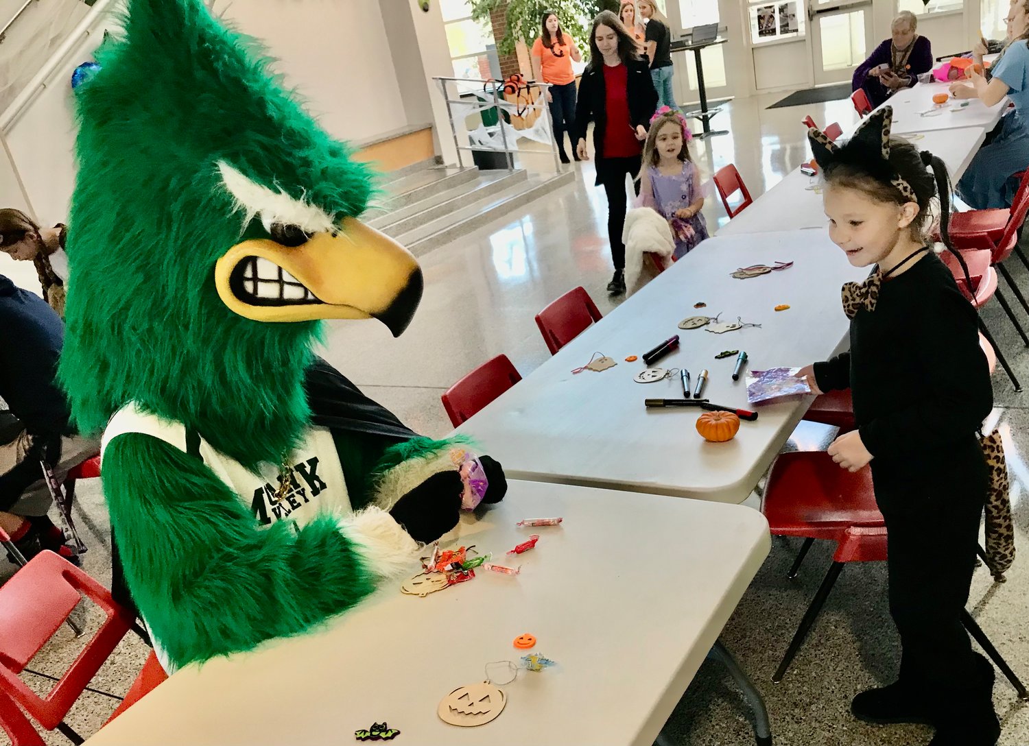 Joslin Yukna, right, of Deerfield chats with Mohawk Valley Community College mascot 'Mo' Oct. 29 during the Halloween Celebration held on its Utica campus for area families.