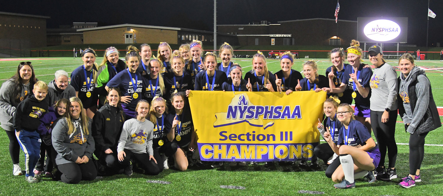 The HP field hockey team celebrates with their banner after winning the Section III Class B championship Sunday night in Verona. Holland Patent topped New Hartford 1-0.