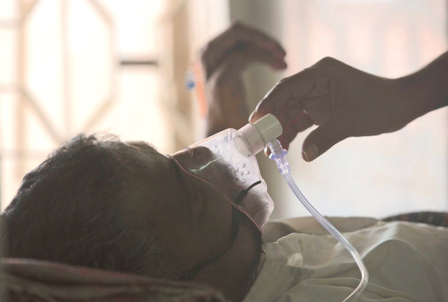 A relative adjusts the oxygen mask of a tuberculosis patient at a TB hospital on World Tuberculosis Day in Hyderabad, India, March 24, 2018. The number of people infected with tuberculosis, including the kind resistant to drugs, rose globally for the first time in years, according to a report issued Thursday, Oct. 27, by the World Health Organization.