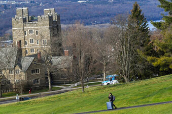 A Cornell University student walks along the campus in Ithaca, N.Y., on Dec. 16, 2021, with luggage in tow. Cornell University has announced the temporary suspension of fraternity parties after a student reported being sexually assaulted on Sunday, Nov. 6, 2022, and four others were reportedly drugged at off-campus housing in recent weeks, university leaders said this week.