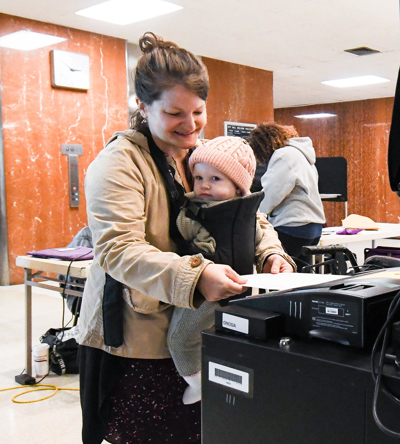 Brit Kuhl casts her ballot with her daughter at the polling station located at Utica City Hall on Tuesday. Oneida County election commissioners reported a busy day at the polls, with some 4,500 to 4,700 voters each hour going to cast their ballots across the county.