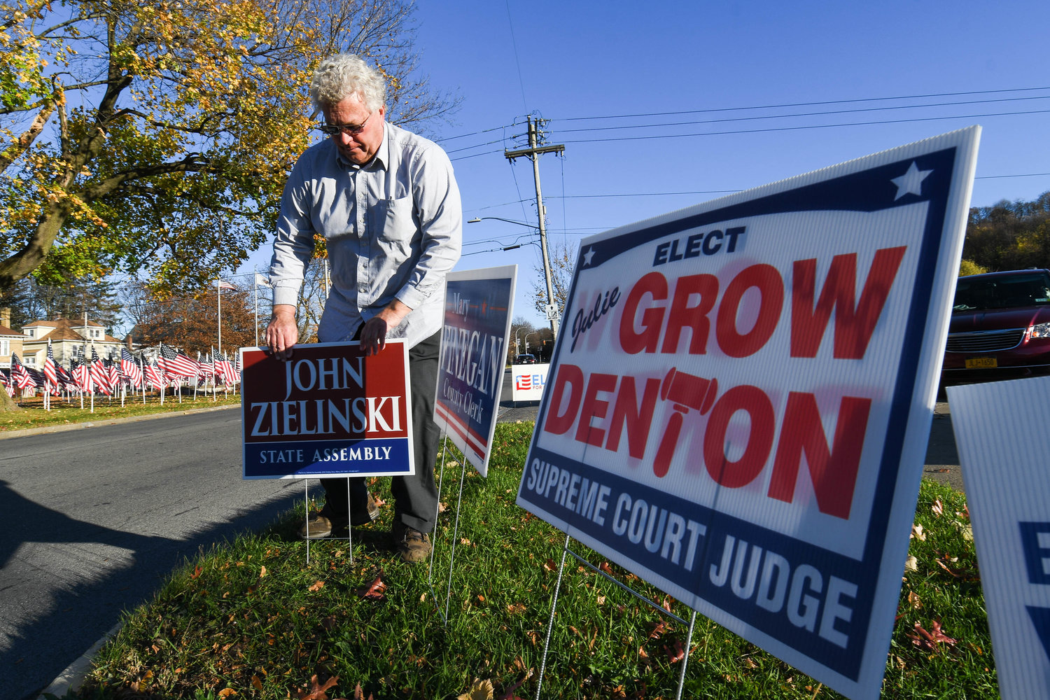 State Assembly candidate John Zielinski places a lawn sign near the entrance to the Parkway Center on Tuesday, Nov. 8 in Utica. Oneida County election commissioners reported a busy day at the polls, with some 4,500 to 4,700 voters each hour going to cast their ballots across the county.