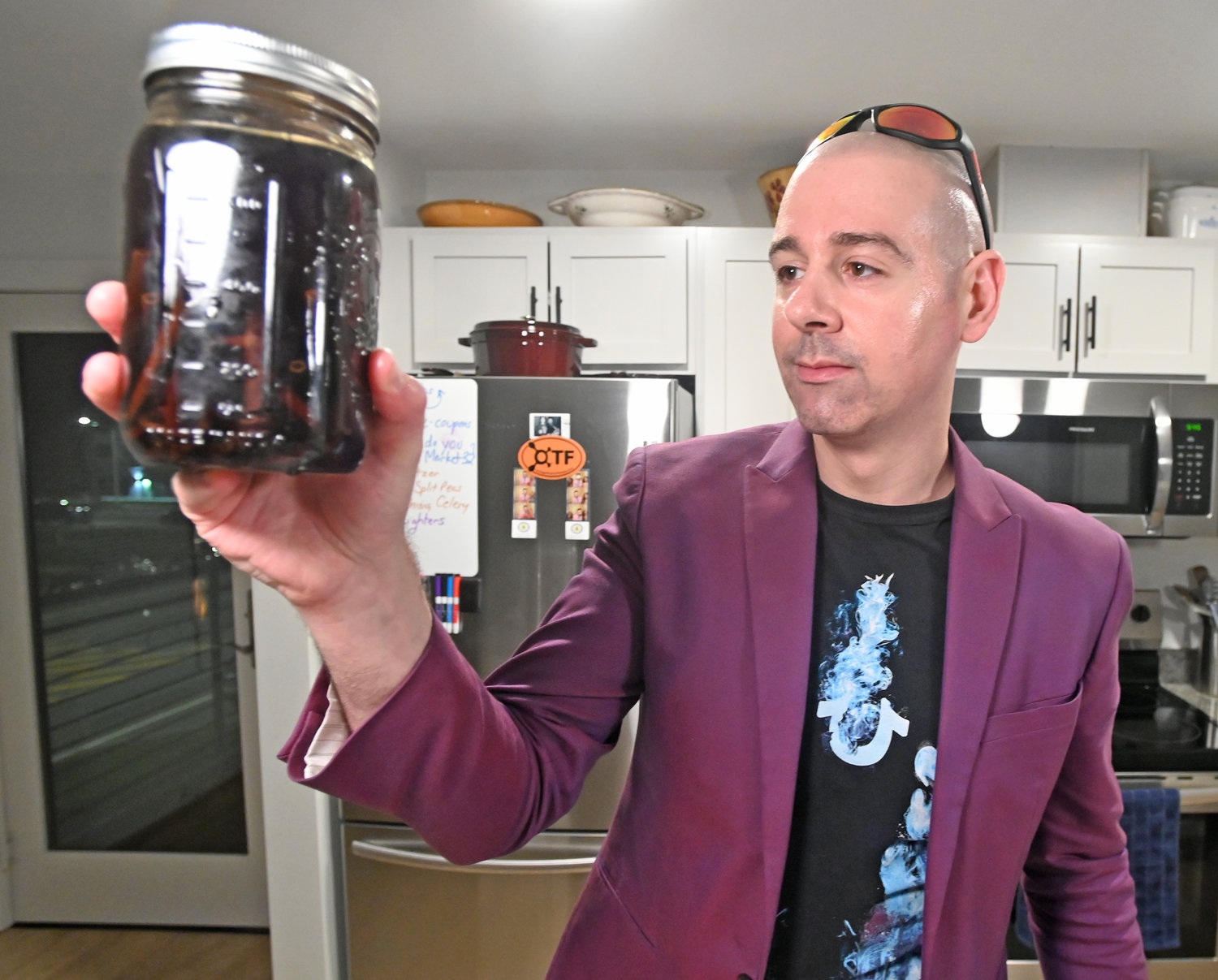 James Daino holds up his special concoction of vanilla extract Wednesday in his Rome kitchen.