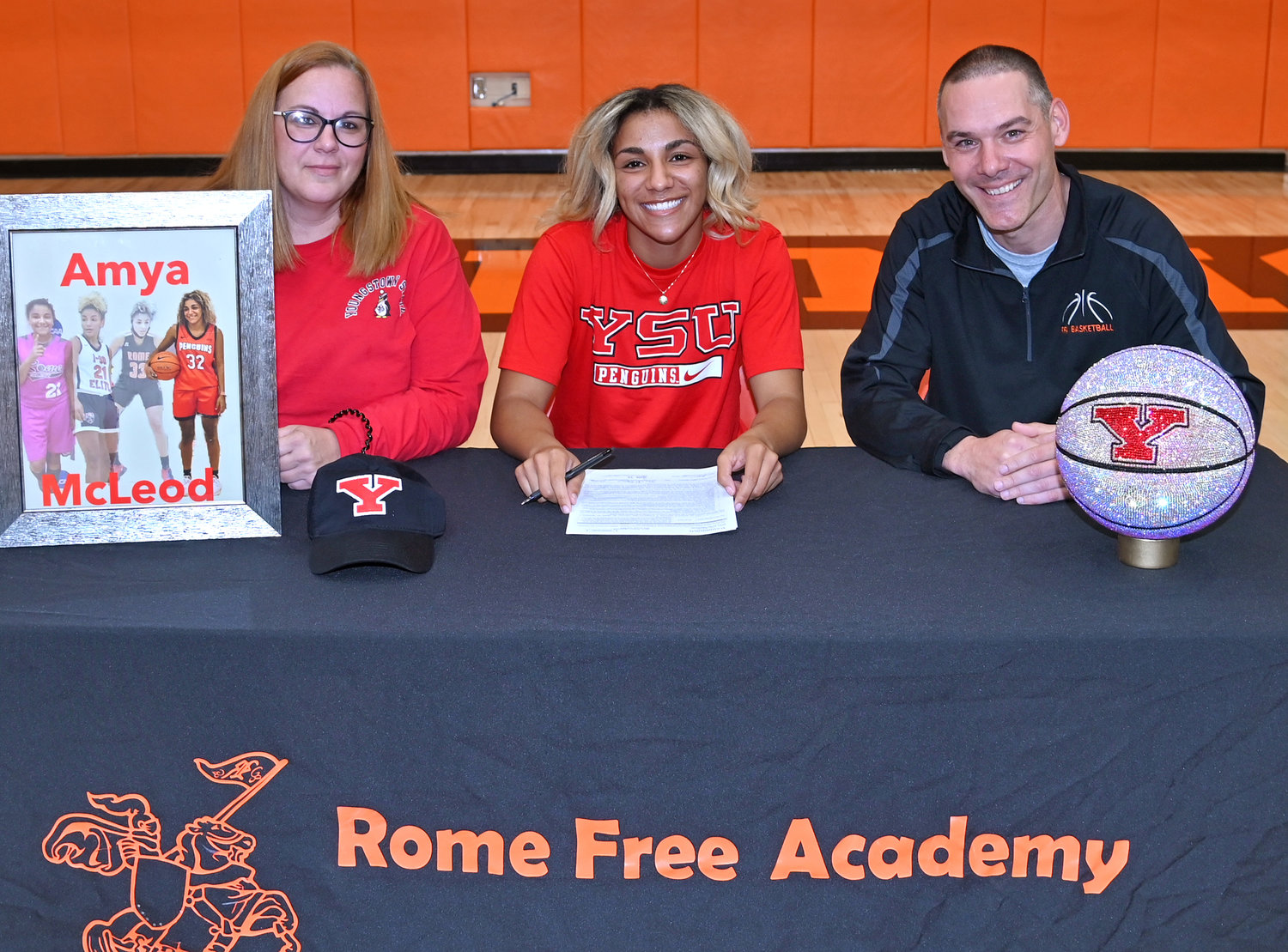 Amya McLeod with her mother Toni St. Thomas and Rome Free Academy girls head basketball coach Al Bevilacqua Thursday as she signed her National Letter of Intent to play Division I college basketball at Youngstown State in Ohio.