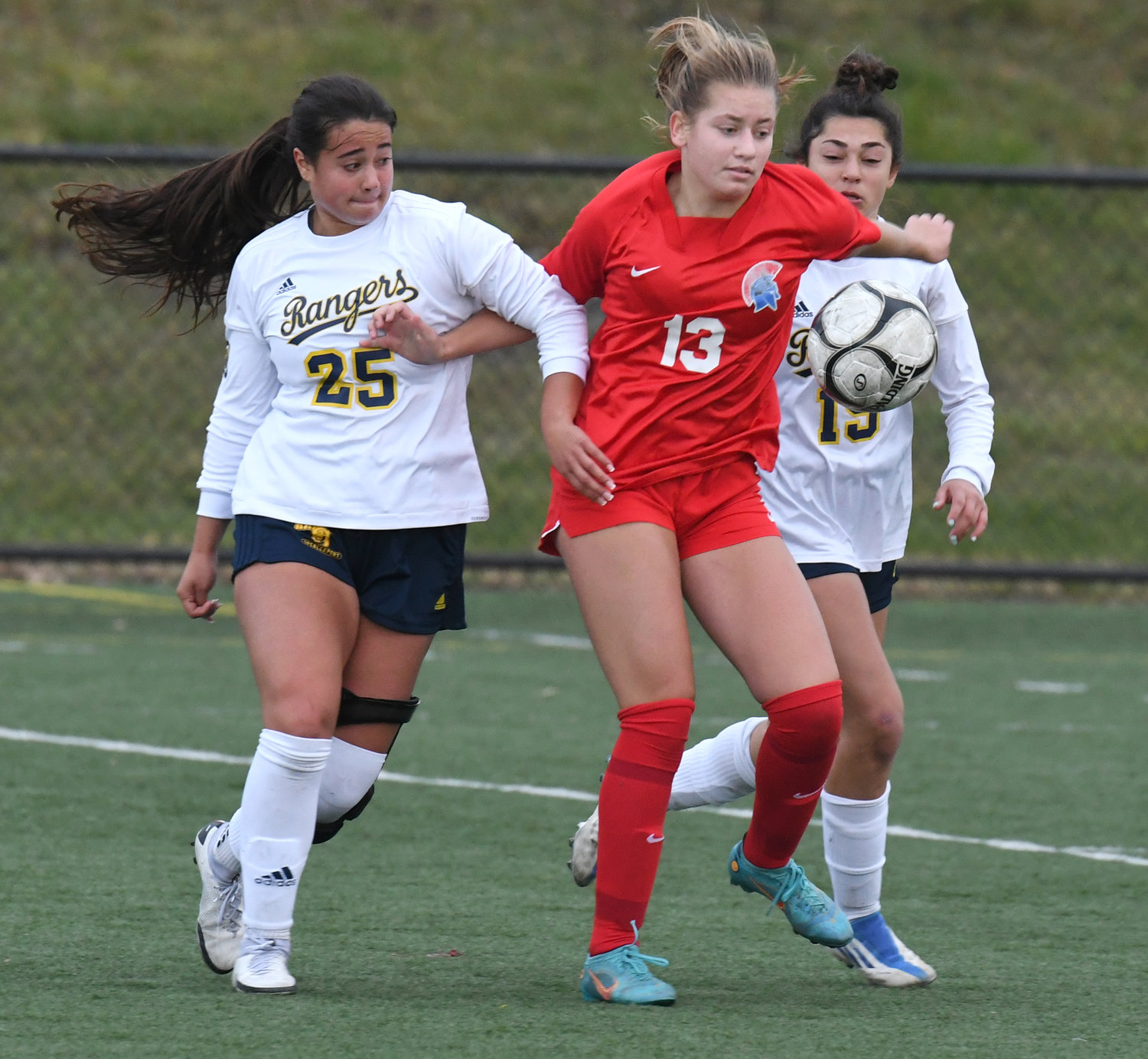 New Hartford's Willa Pratt fights through the defense of Spencerport's Isabella Fiorillo and Jamie Keens in overtime of the state Class A semifinal game Saturday at Tompkins Cortland Community College. Pratt had a goal in the second half.