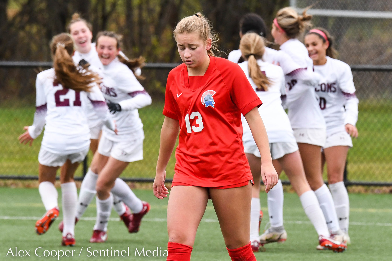New Hartford player Willa Pratt (13) reacts as Albertus Magnus players celebrate after scoring a goal during the Class A state final on Sunday at Tompkins-Cortland Community College. The Spartans lost 3-1.